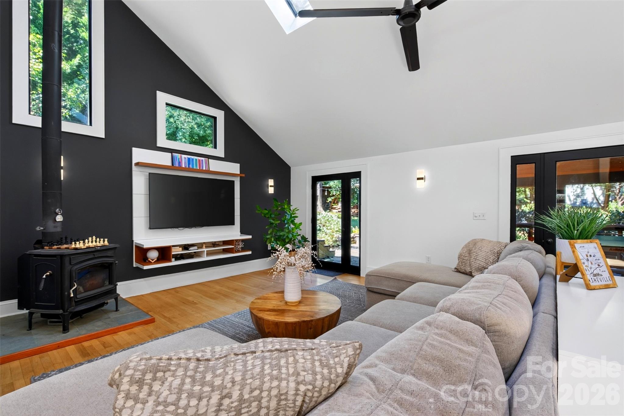 Living room has a wood stove and exterior doors to backyard or covered patio - 5 Inglewood Road, Asheville