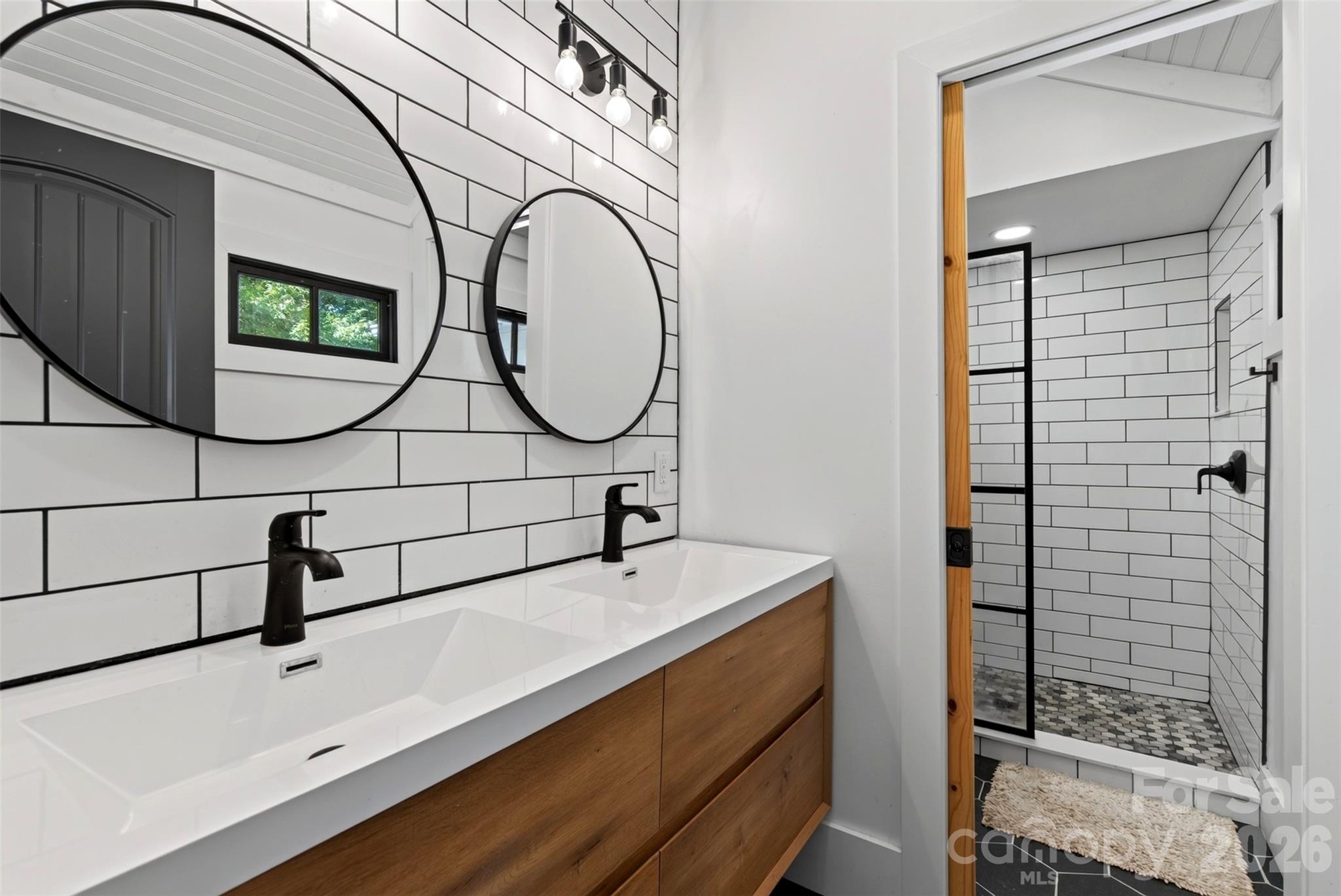 Double vanity, and tile shower in primary bathroom - 5 Inglewood Road, Asheville