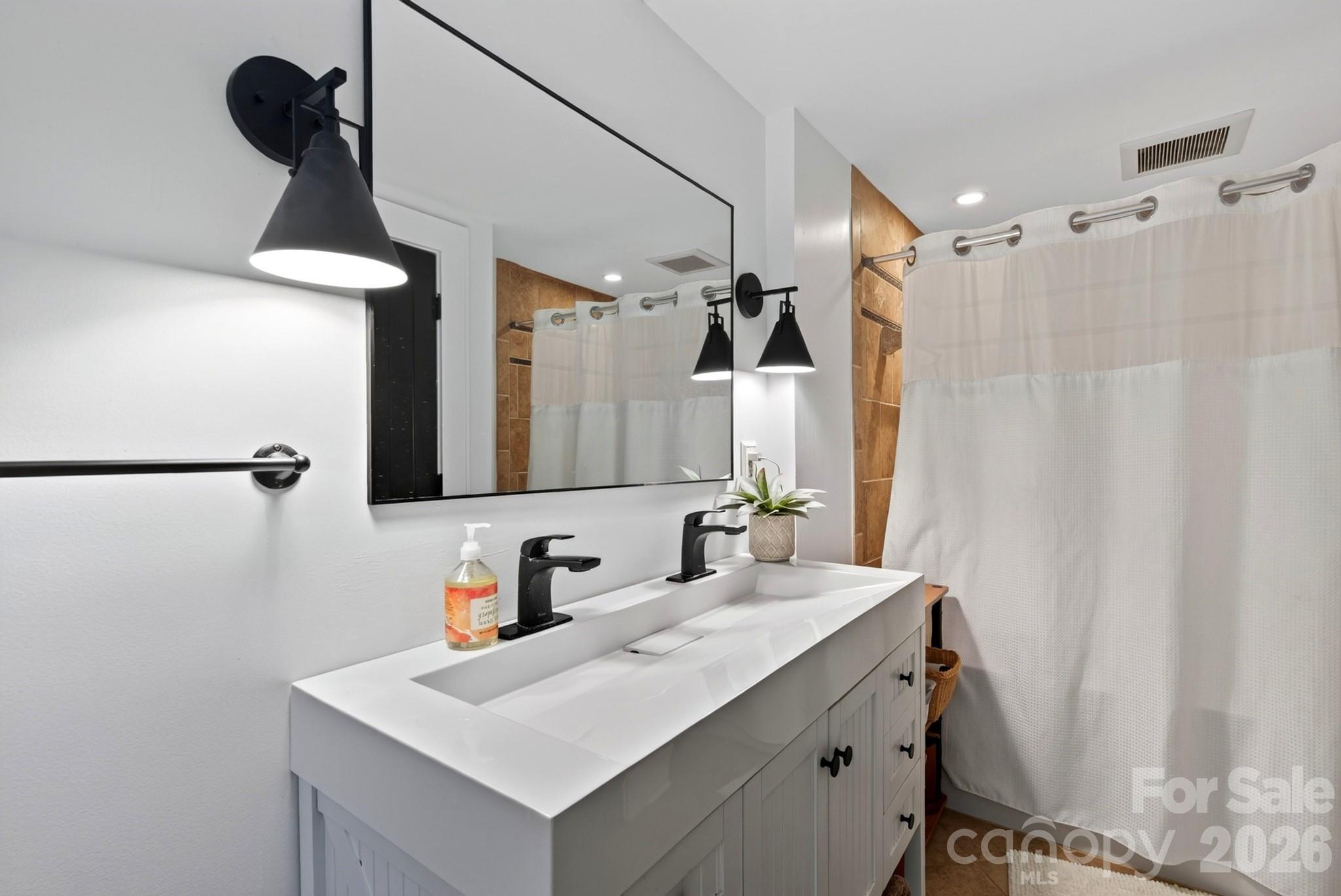 2nd bedroom ensuite with single stone vanity and shower/tub - 5 Inglewood Road, Asheville
