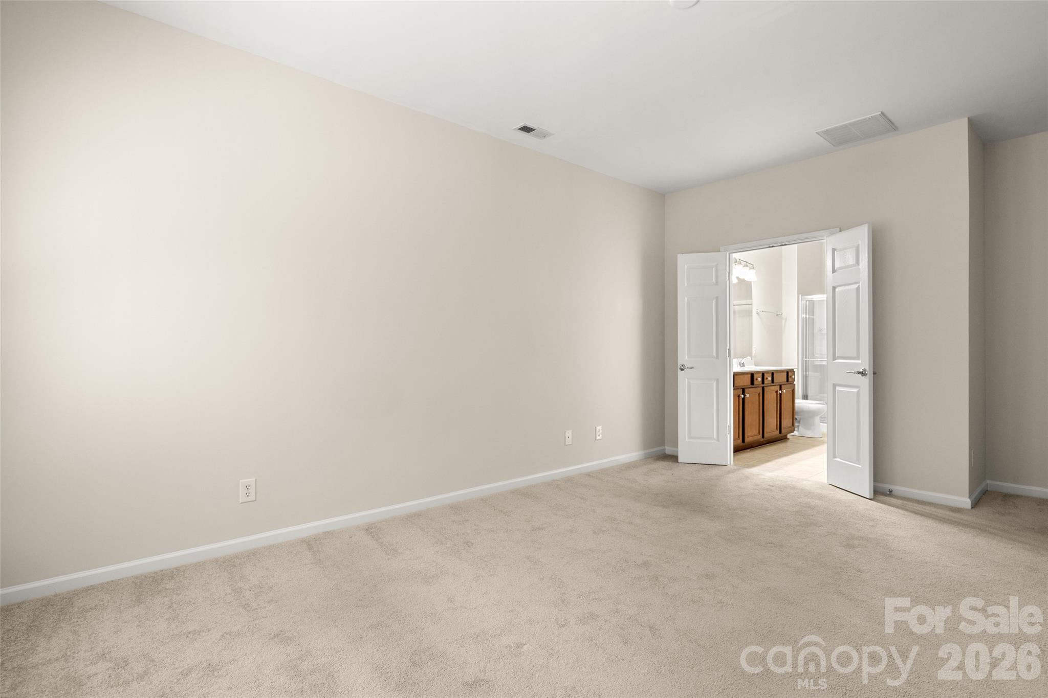 Primary bedroom with French doors to ensuite bathroom - 9015 Smokey Hill Lane, Indian Land