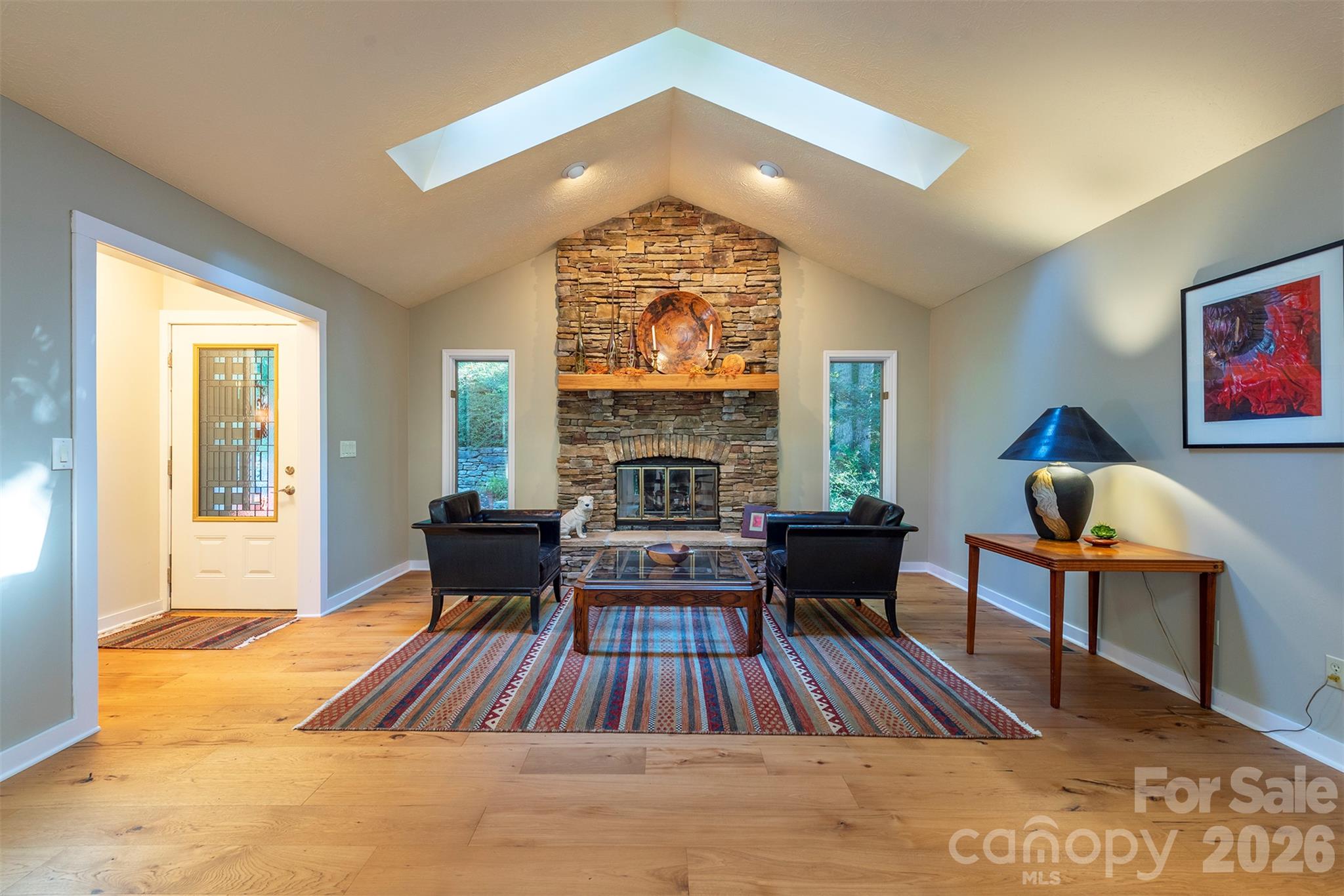 The spacious great room is a large open floor plan living room and dining room, with vaulted ceilings, light pouring into the skylights, and room for so much customization! - 190 Ridgeview Drive, Hendersonville