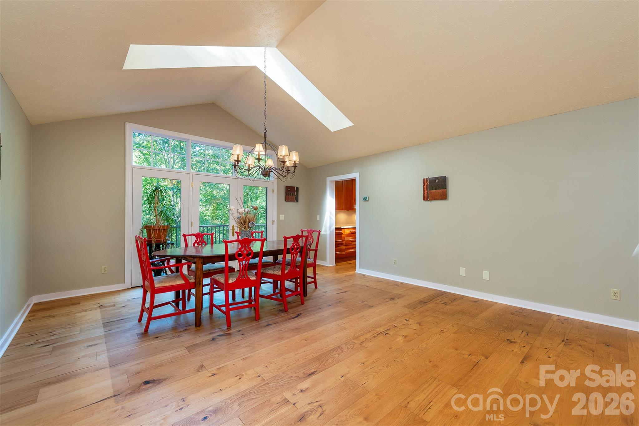 The spacious great room is a large open floor plan living room and dining room, with vaulted ceilings, light pouring into the skylights, and room for so much customization! - 190 Ridgeview Drive, Hendersonville
