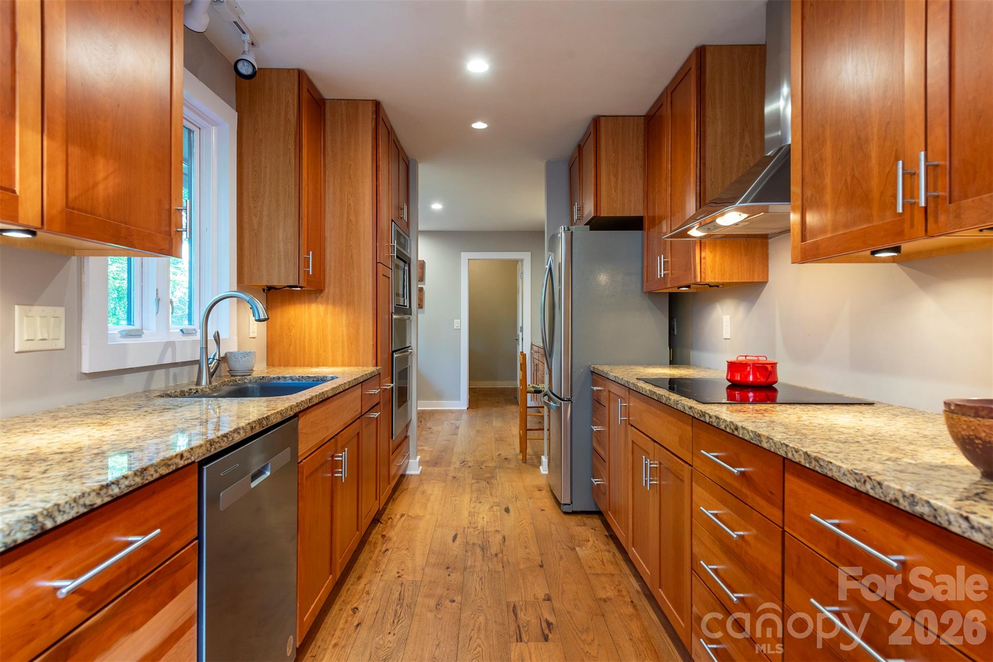 The galley kitchen is absolutely gorgeous! Granite countertops, stainless steel appliances, a Thermador wall oven, a warming drawer, and so much thoughtful storage space! - 190 Ridgeview Drive, Hendersonville