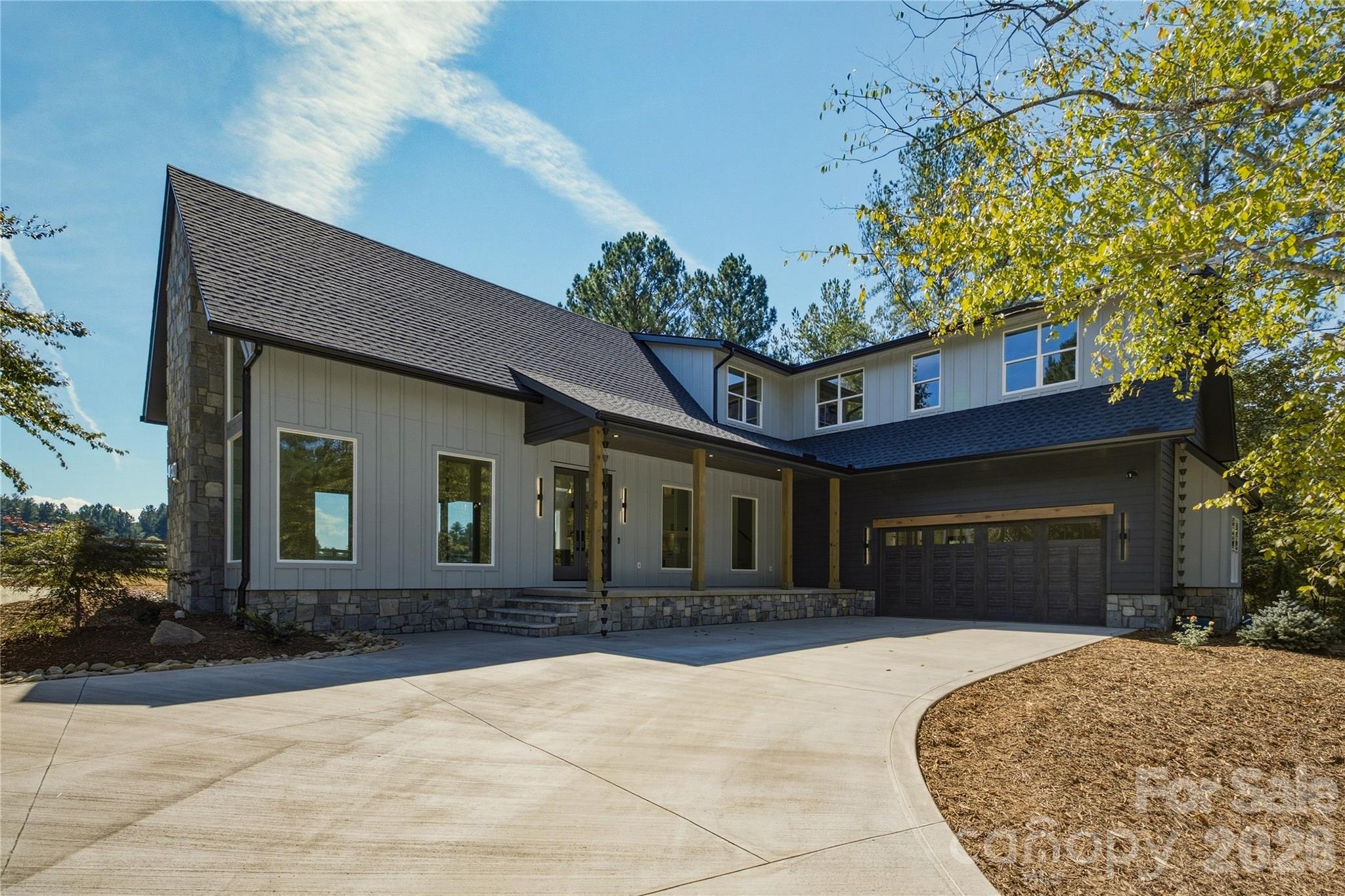 The wood accents on the front porch add a very natural feel to the entry of the home and the carraige house style garage door opens up to an oversized place to park your vehicles. - 2303 Paddock Circle, Morganton