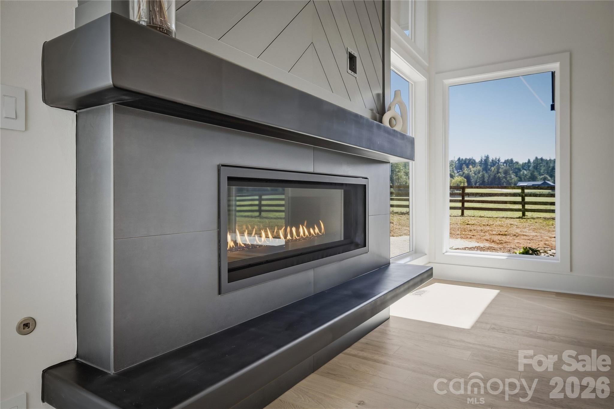 The focal point of the great room is the 54" linear gas fireplace. Do not miss the view of the pasture out the windows. - 2303 Paddock Circle, Morganton