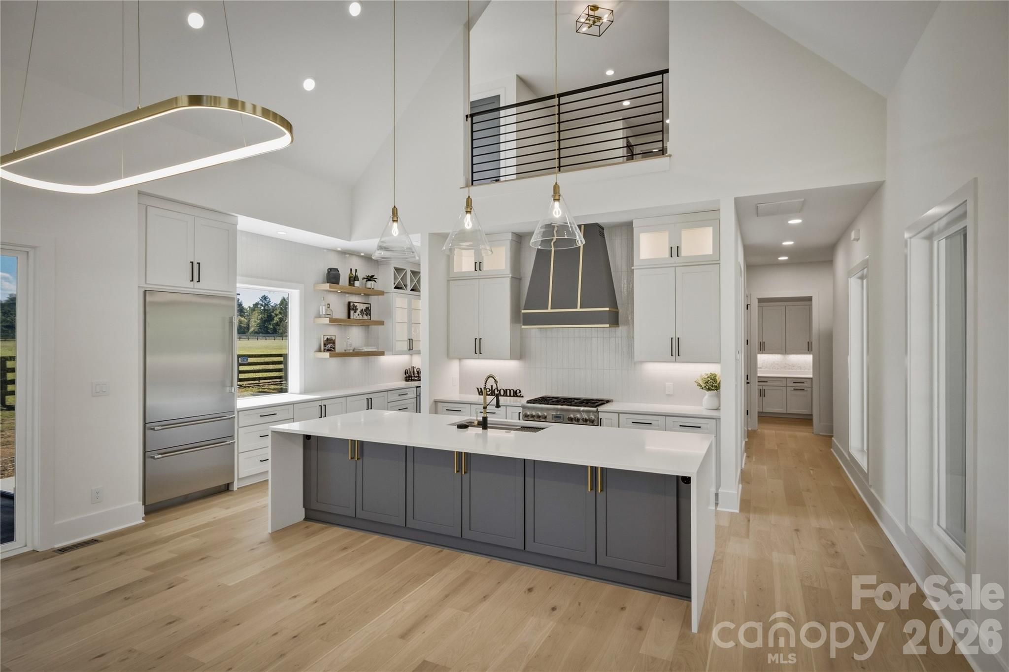 The quartz countertops and the modern light fixtures set the stage. The island has a modern waterfall countertop. There is even cabinetry tucked under the overhang of the island for a bit of extra storage. - 2303 Paddock Circle, Morganton