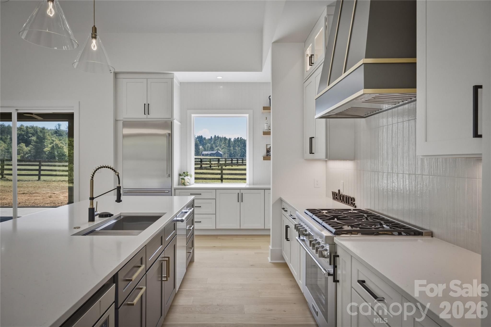 There is a contemporary sink and faucet located on the islandm abd the stainless panelled Thermador refrigerator is built into the cabinetry for a high end look. - 2303 Paddock Circle, Morganton