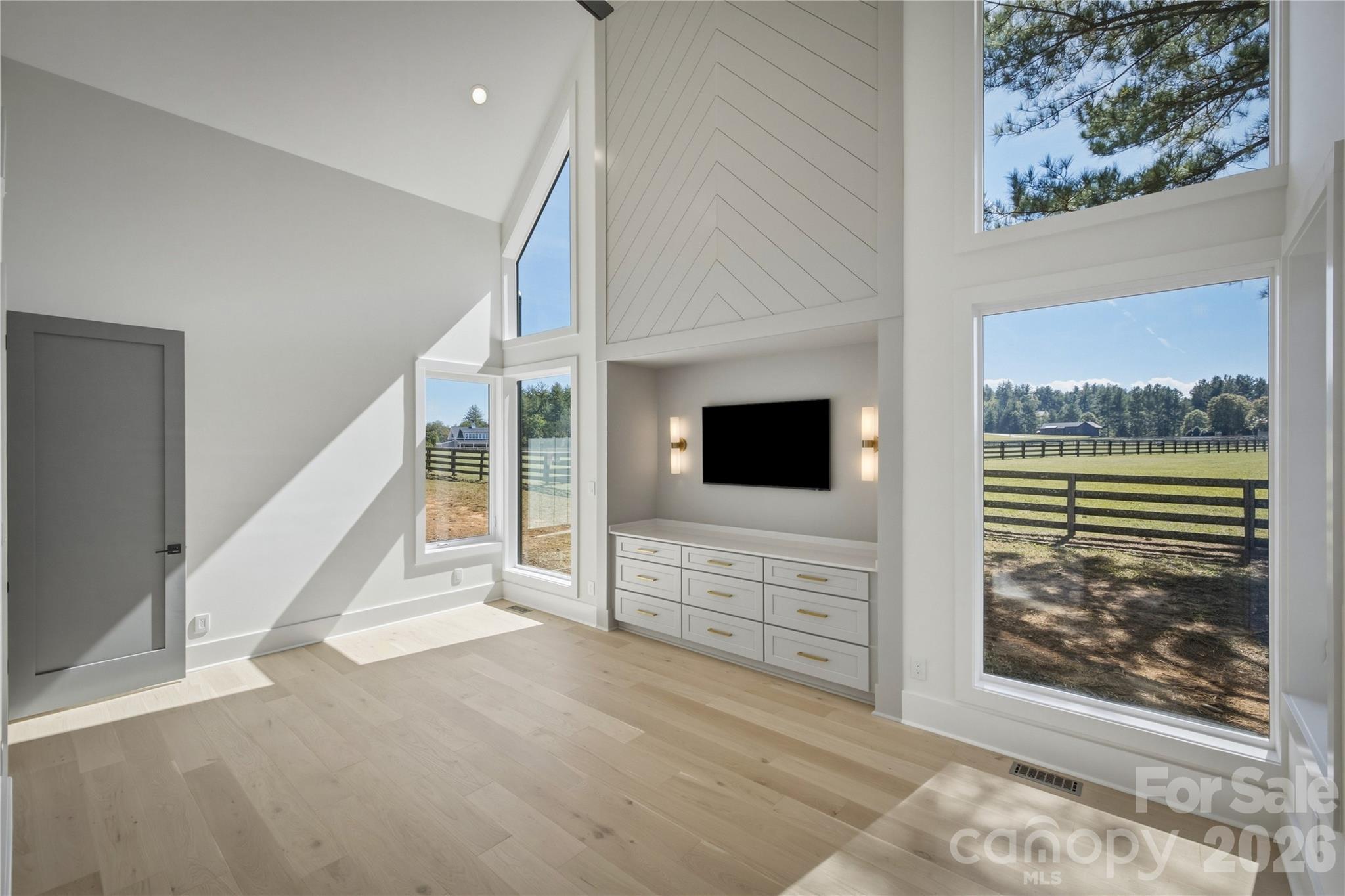 The vistas out the wall of windows is quite breathtaking, and the really tall ceilings in this room are exquisite! - 2303 Paddock Circle, Morganton