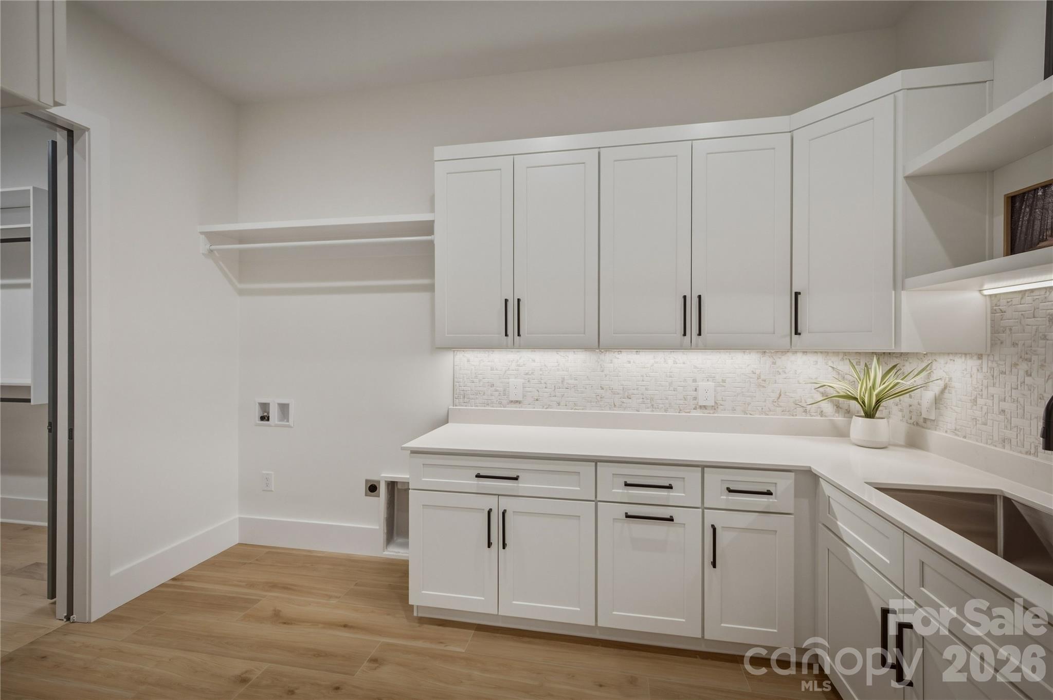 The laundry and mudroom are located conveniently through a doorway in the owners' closet. There are tons of cabinets and a large sink. - 2303 Paddock Circle, Morganton