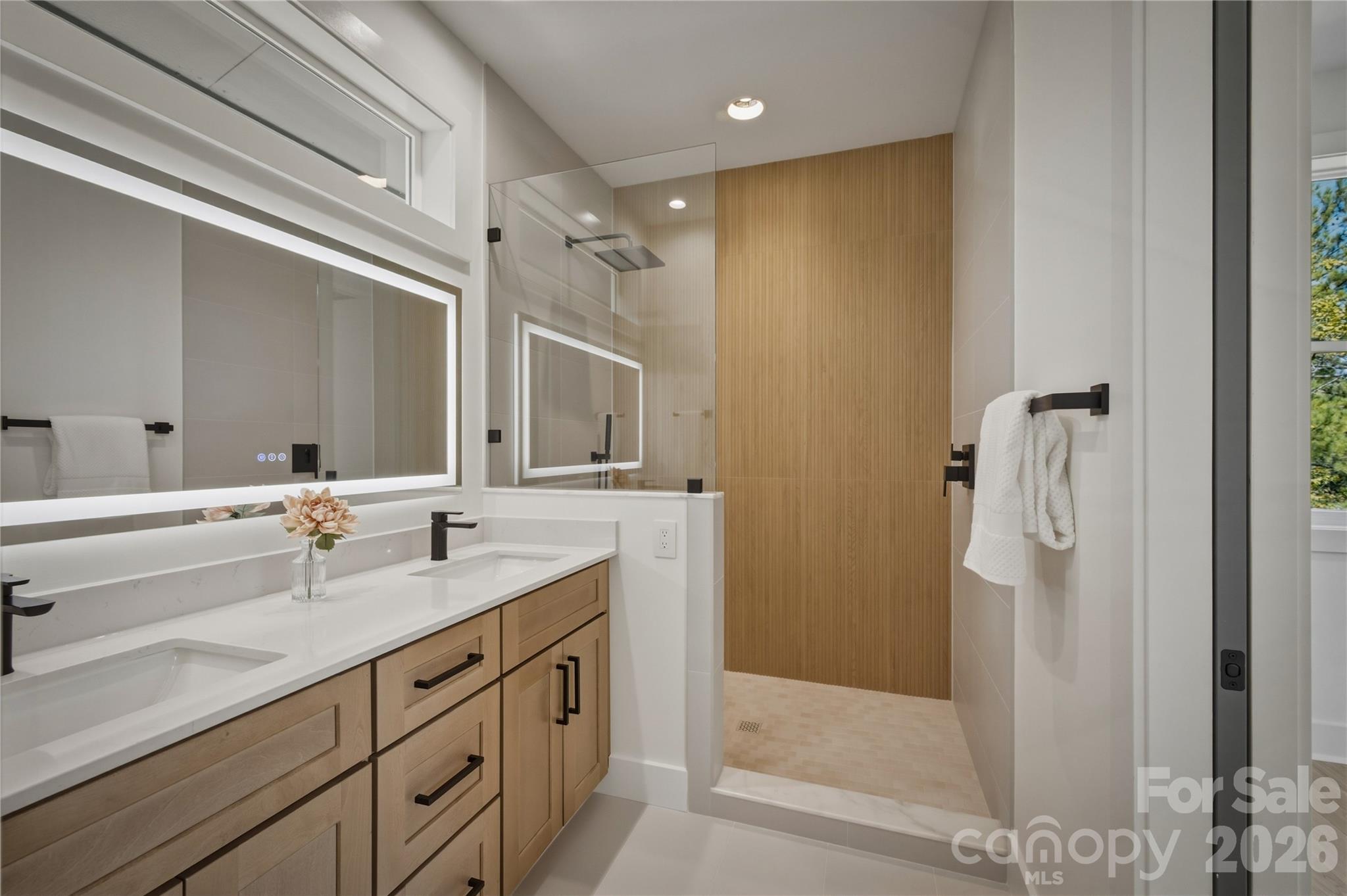 This bathroom has double sinks, a nice sized vanity, and a lighted mirror. - 2303 Paddock Circle, Morganton
