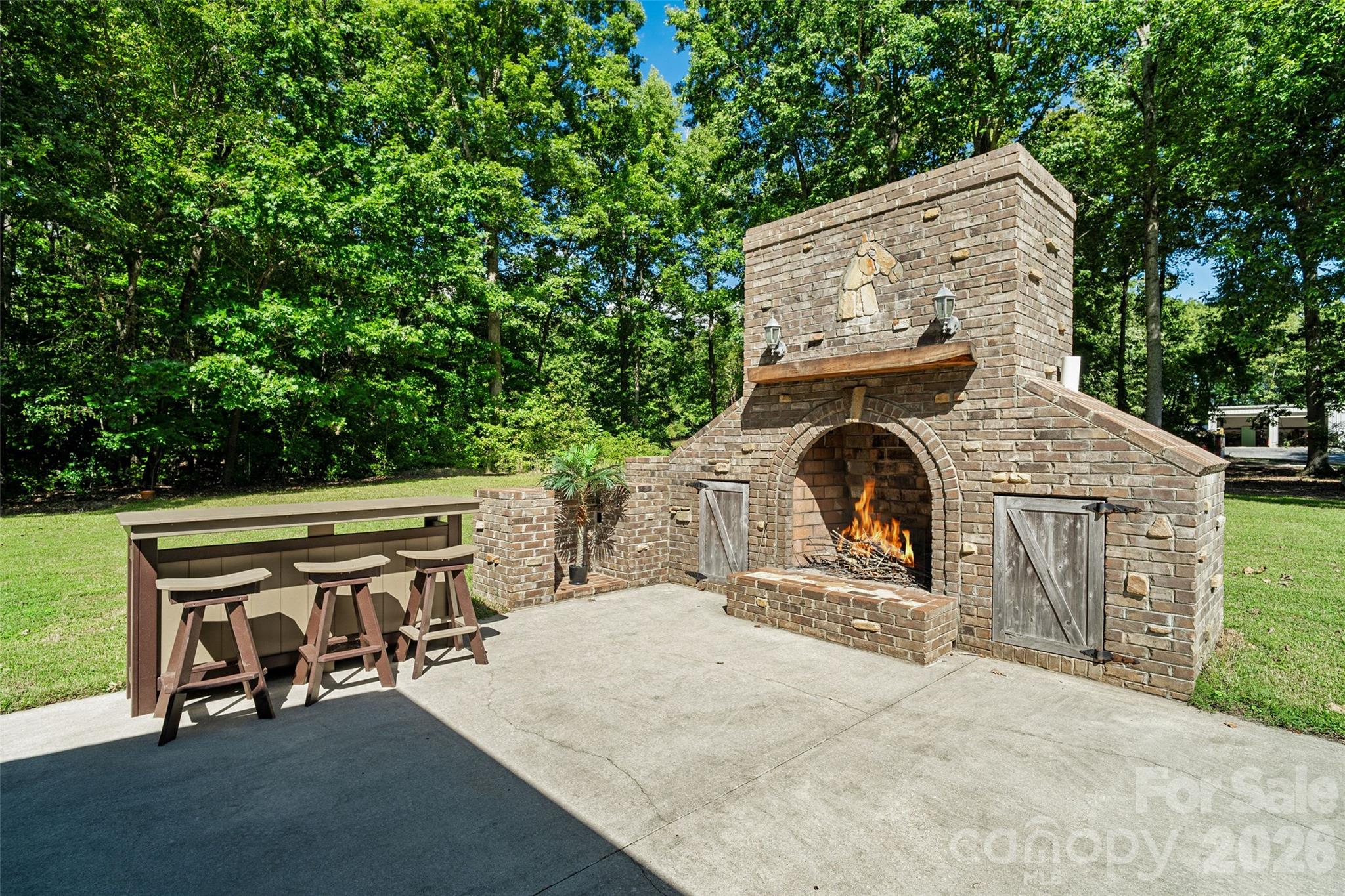 Custom built outdoor fireplace with sconces and wood storage - 996 Beamguard Road, Clover