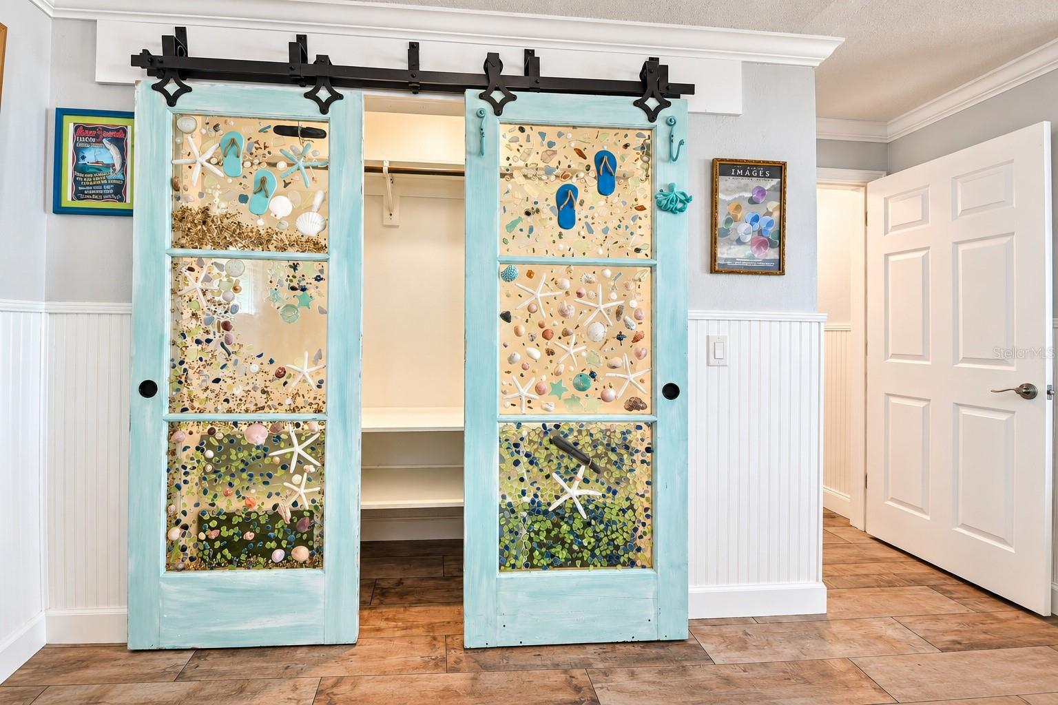 Primary bedroom closet with custom glass barn doors. - 123 E YELKCA TER, EDGEWATER