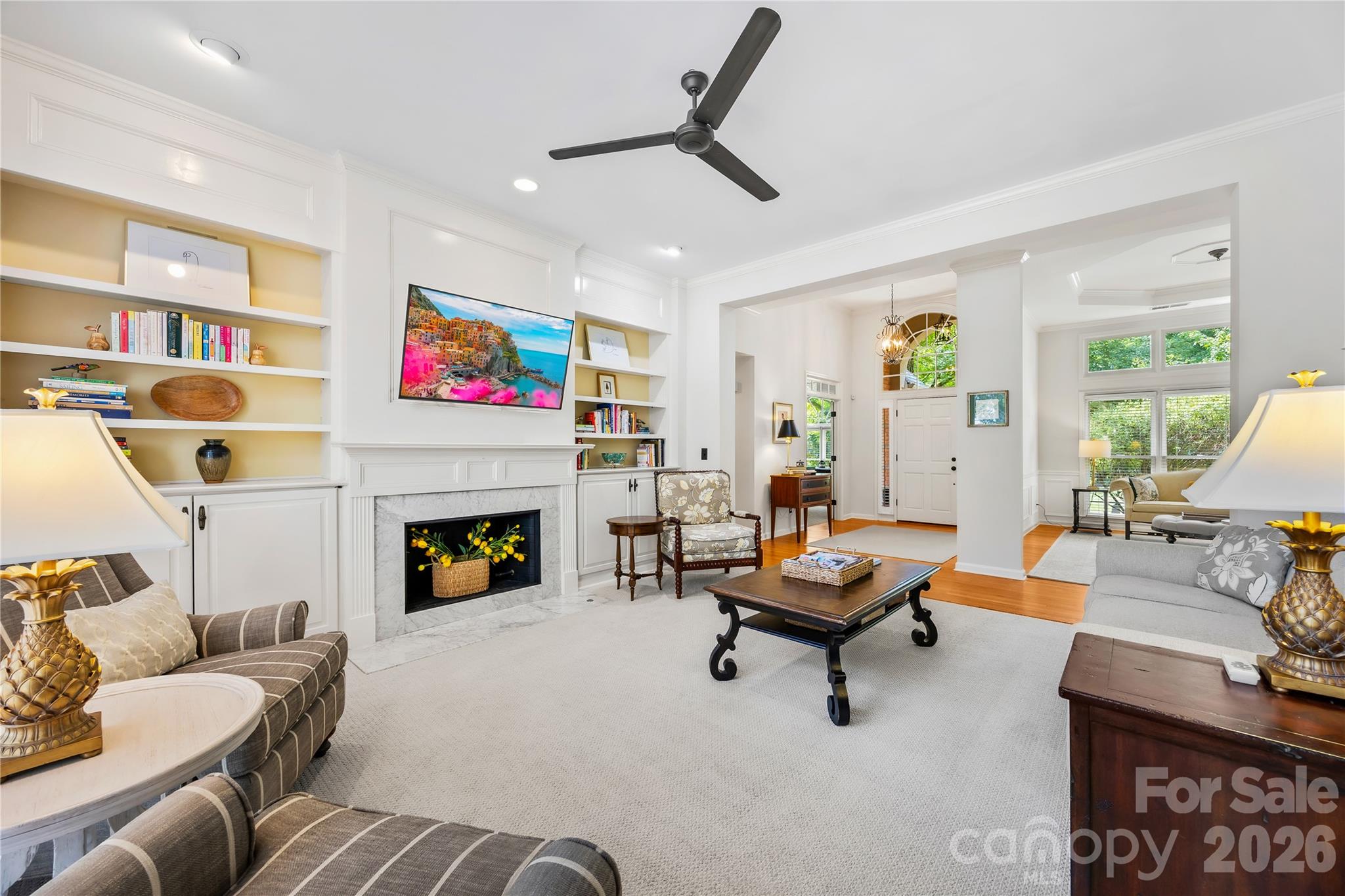 Family room with custom cabinets and shelves on either side of the fireplace - 15728 Delancey Lane, Huntersville