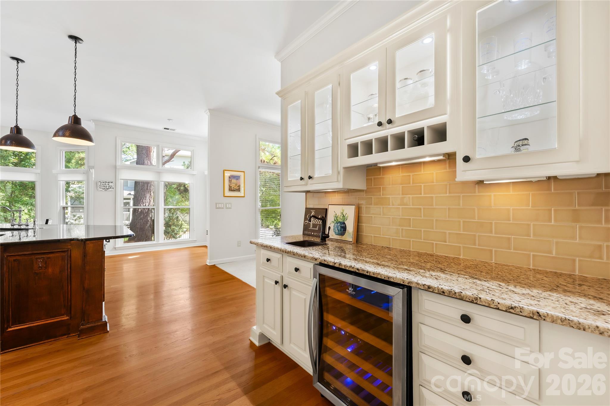 Host guests effortlessly from the dedicated beverage station, complete with a bar sink and a 30-bottle dual-zone wine fridge - 15728 Delancey Lane, Huntersville