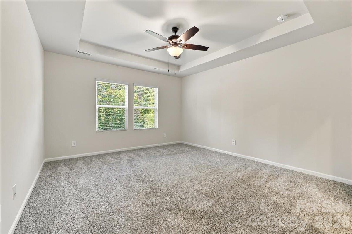 Primary bed with tray ceiling and lots of natural light. - 151 Bird Dog Drive, Mooresville