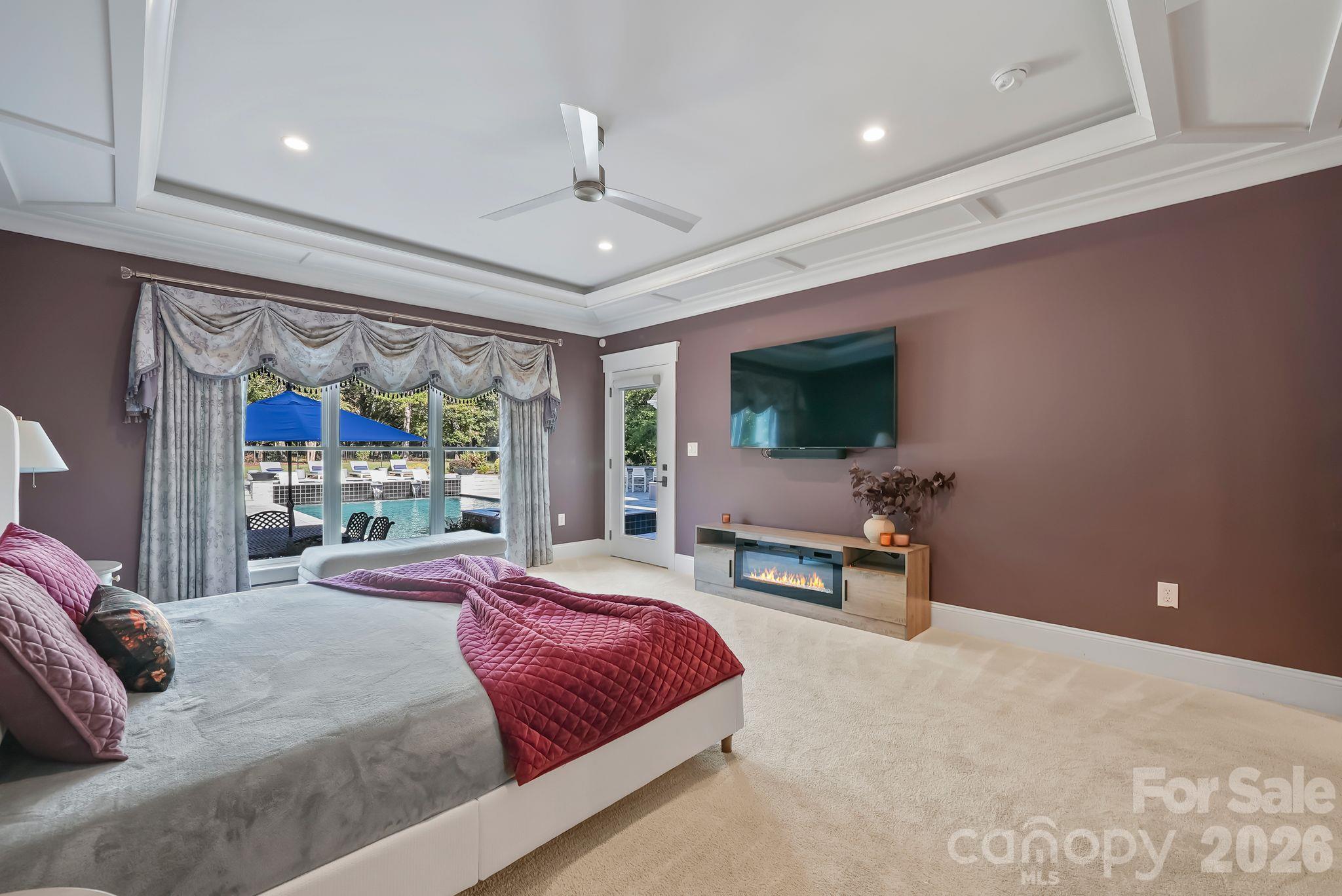 Spacious primary bedroom with tray ceilings and access to the covered back patio - 268 Milford Circle, Mooresville