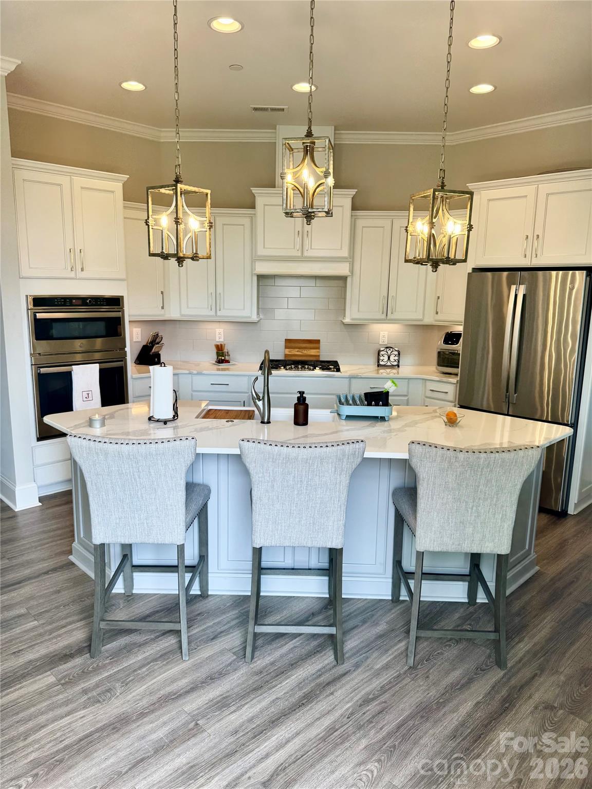 Gourmet Kitchen with sleek quartz counter tops, soft close cabinetry and drawers, custom pantry with pull out appliance shelf, gas counter top range, convection oven and microwave all with modern fixtures - 9065 Treetop Way NW, Concord