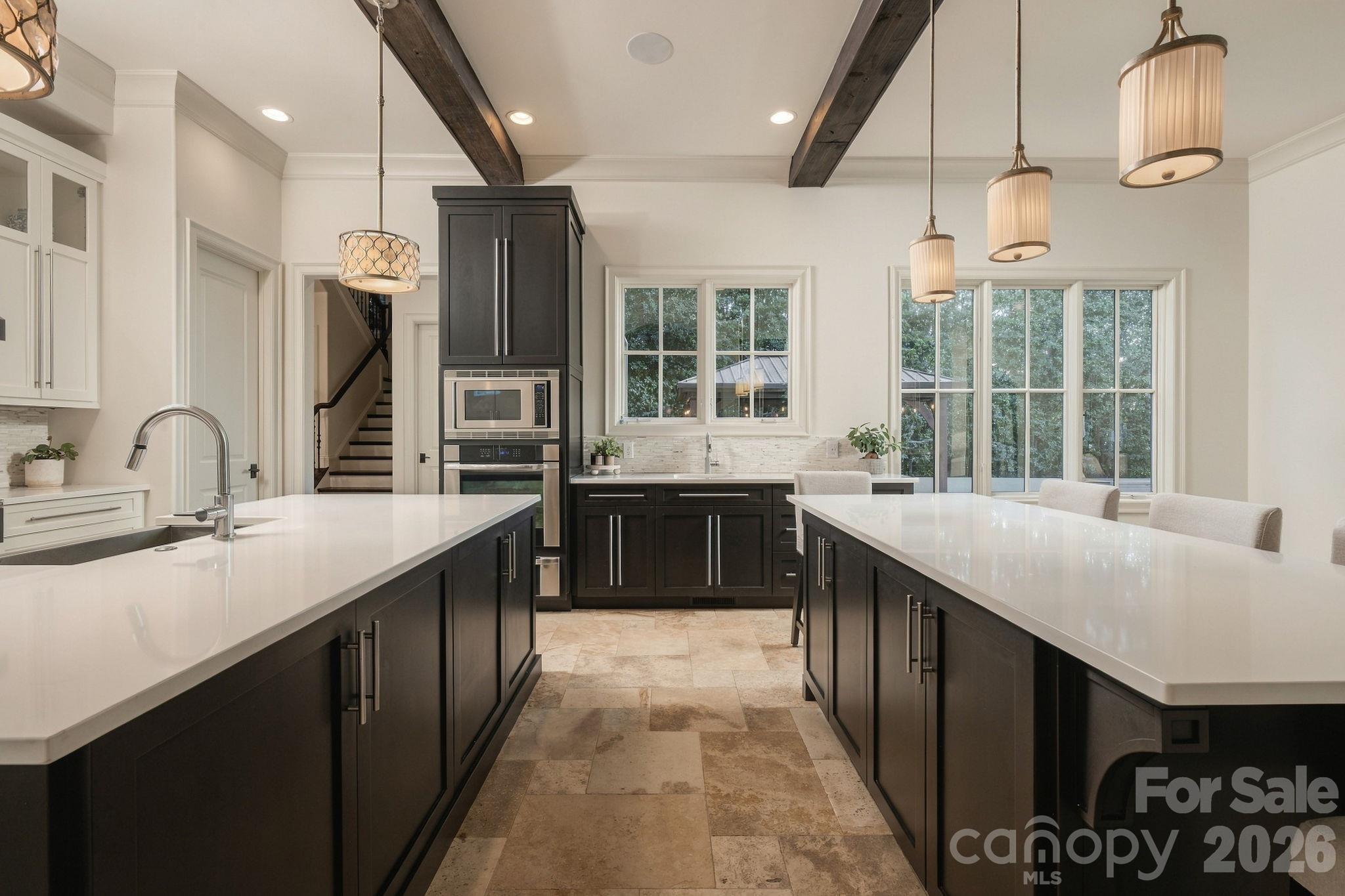 This gorgeous kitchen has a double island with 3 sinks, beautiful cabinetry, beams, sub zero refrigerator, incredible wet bar and SO much more! - 21215 Senlac Lane, Cornelius