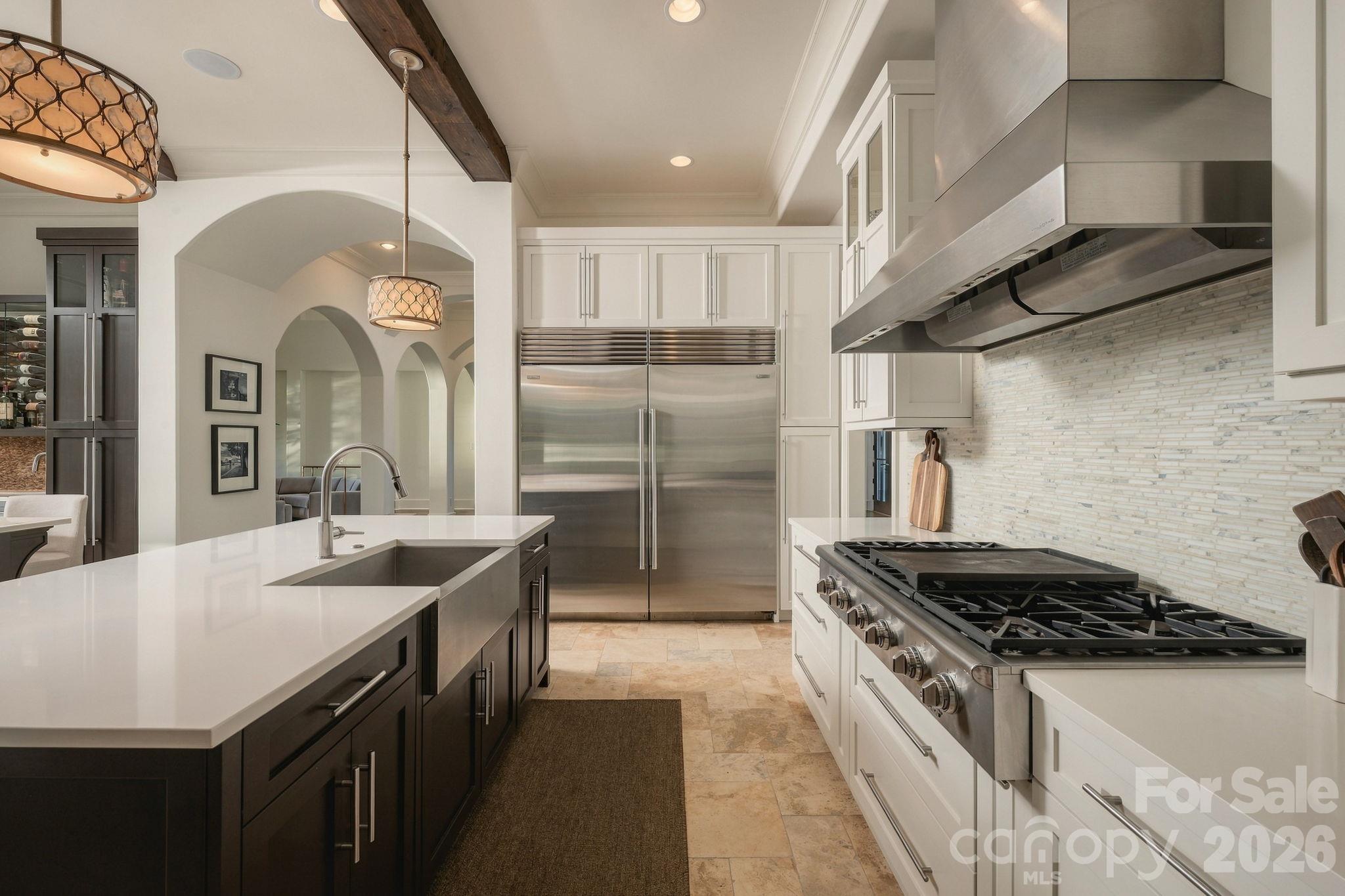 This gorgeous kitchen has a double island with 3 sinks, beautiful cabinetry, beams, sub zero refrigerator, incredible wet bar and SO much more! - 21215 Senlac Lane, Cornelius