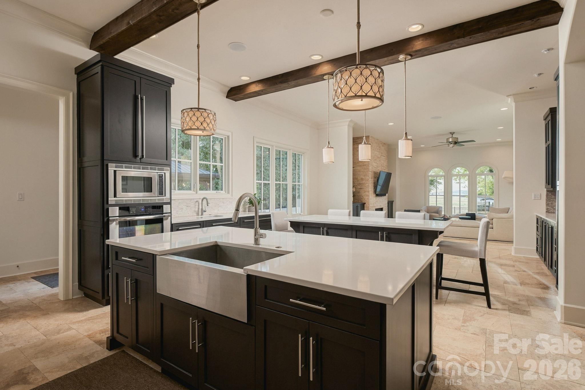 This goregous kitchen has a double island with 3 sinks, beautiful cabinetry, beams, sub zero refrigerator, incredible wet bar and SO much more! - 21215 Senlac Lane, Cornelius
