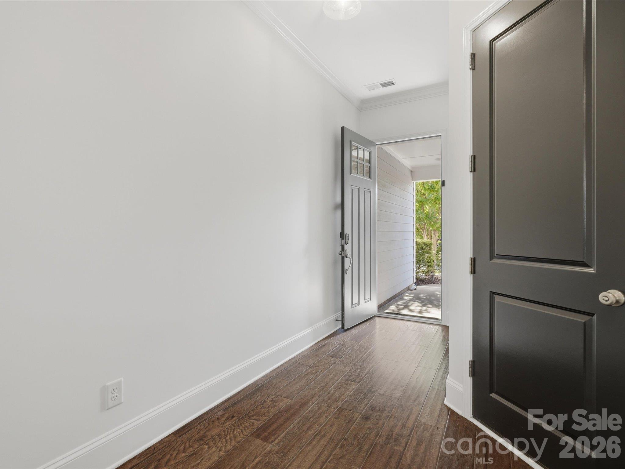 Welcoming foyer with luxury vinyl plank (LVP) flooring, crown molding, and ten-foot ceilings leading into the bright, open-concept main level. - 337 Belton Street, Charlotte