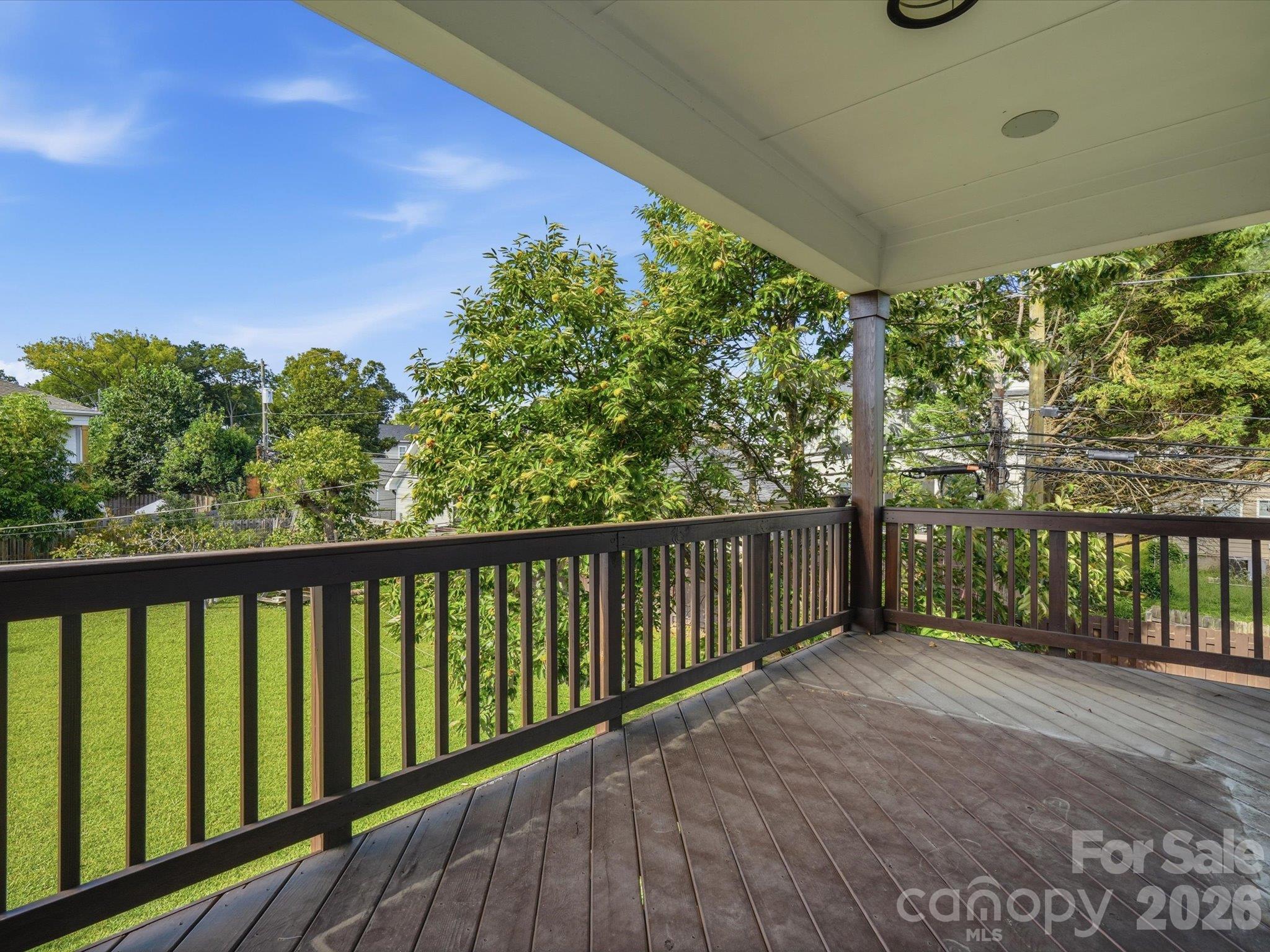 Private covered upper deck off the primary suite overlooking the level, fully fenced backyard and mature trees. - 337 Belton Street, Charlotte
