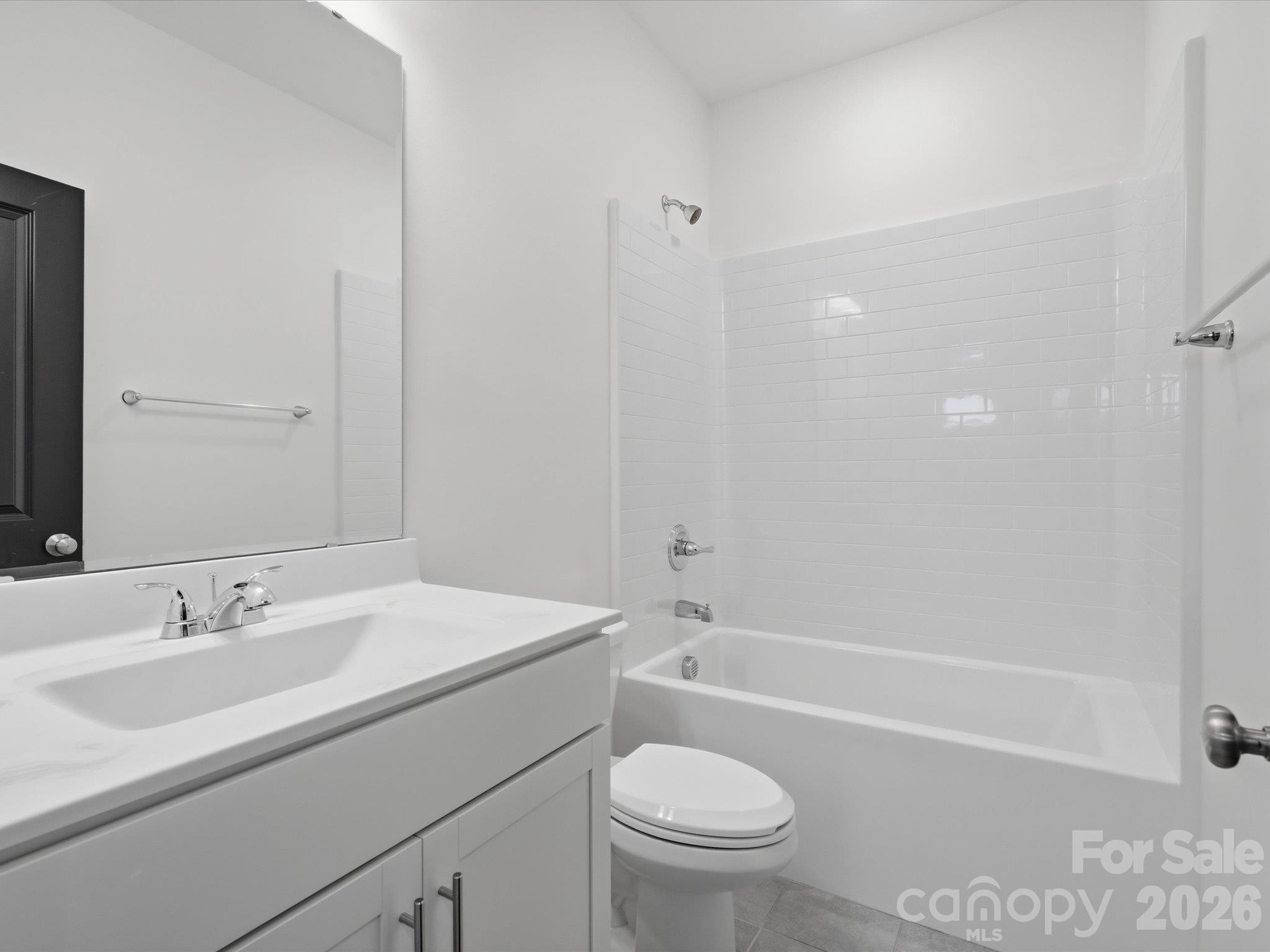 Full upstairs guest bathroom with tub-shower combination, white subway tile surround, and white vanity. - 337 Belton Street, Charlotte