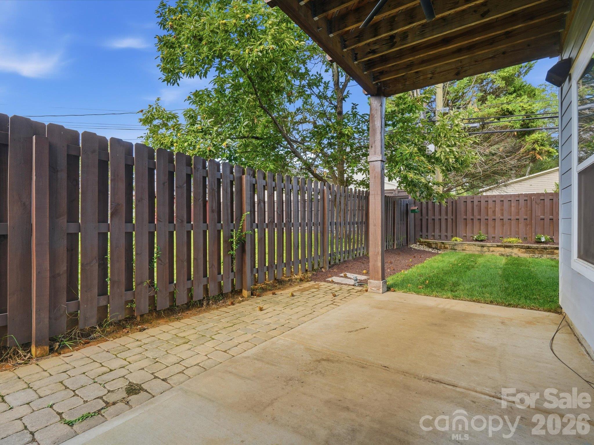 Covered lower patio with Klipsch surround sound and paver walkway, opening to the level, fully fenced backyard. - 337 Belton Street, Charlotte