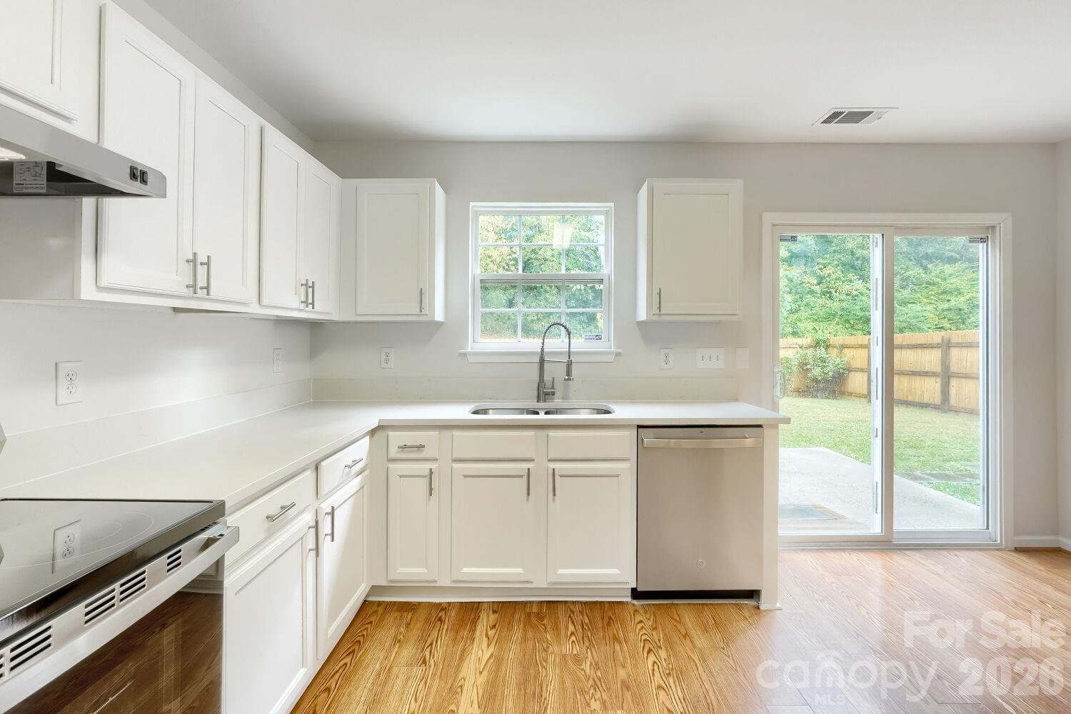 Another view of the Large Kitchen with the Window over sink & view of fenced in backyard from Sliding Door - 5135 Raspberry Knoll Drive, Charlotte