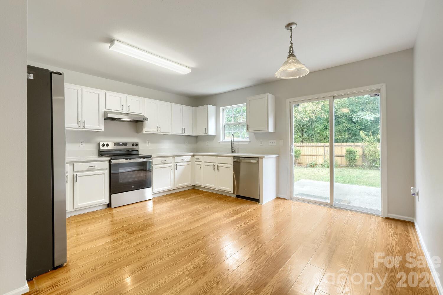 Another view of the Large Kitchen with the view of fenced in backyard from the Sliding Glass Door-Making this a nice Eat-In-Kitchen area - 5135 Raspberry Knoll Drive, Charlotte