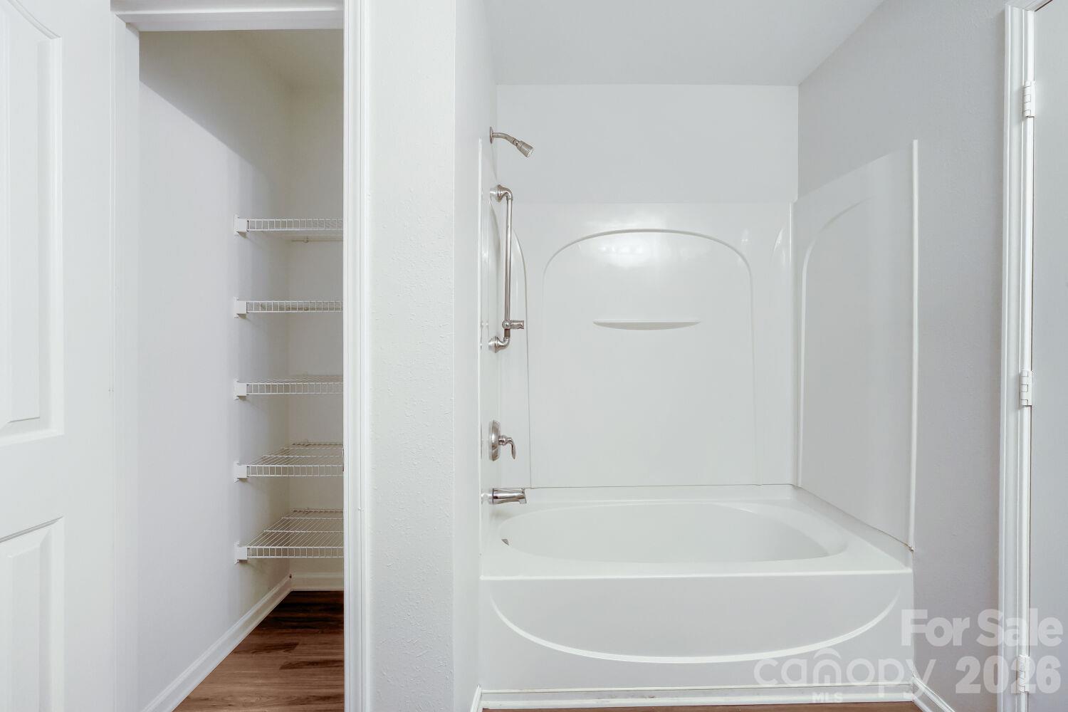Primary Bathroom with new LPV flooring with view of Linen closet & bath tub/shower combination - 5135 Raspberry Knoll Drive, Charlotte