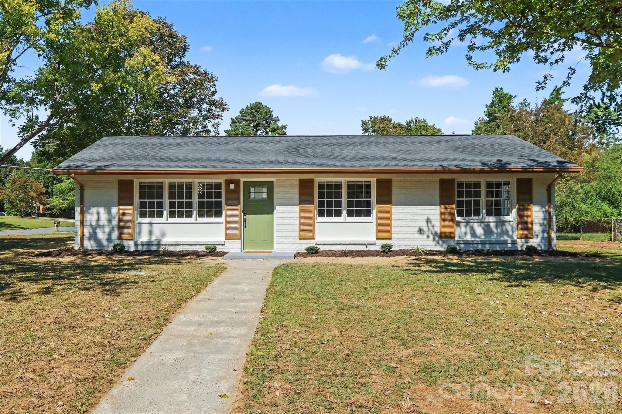 Front Exterior: Freshly painted exterior featuring a new roof, gutters, updated front door, and manicured front lawn. - 3801 Hillock Court, Charlotte