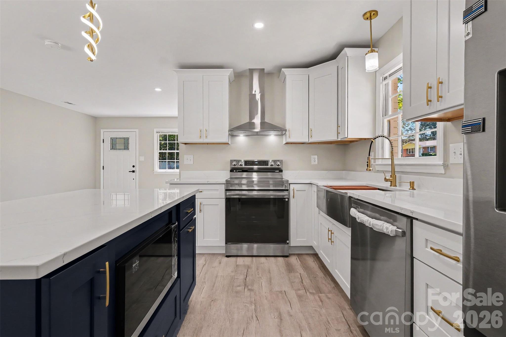 New kitchen with a stylish navy center island, brand-new cabinetry. - 3801 Hillock Court, Charlotte