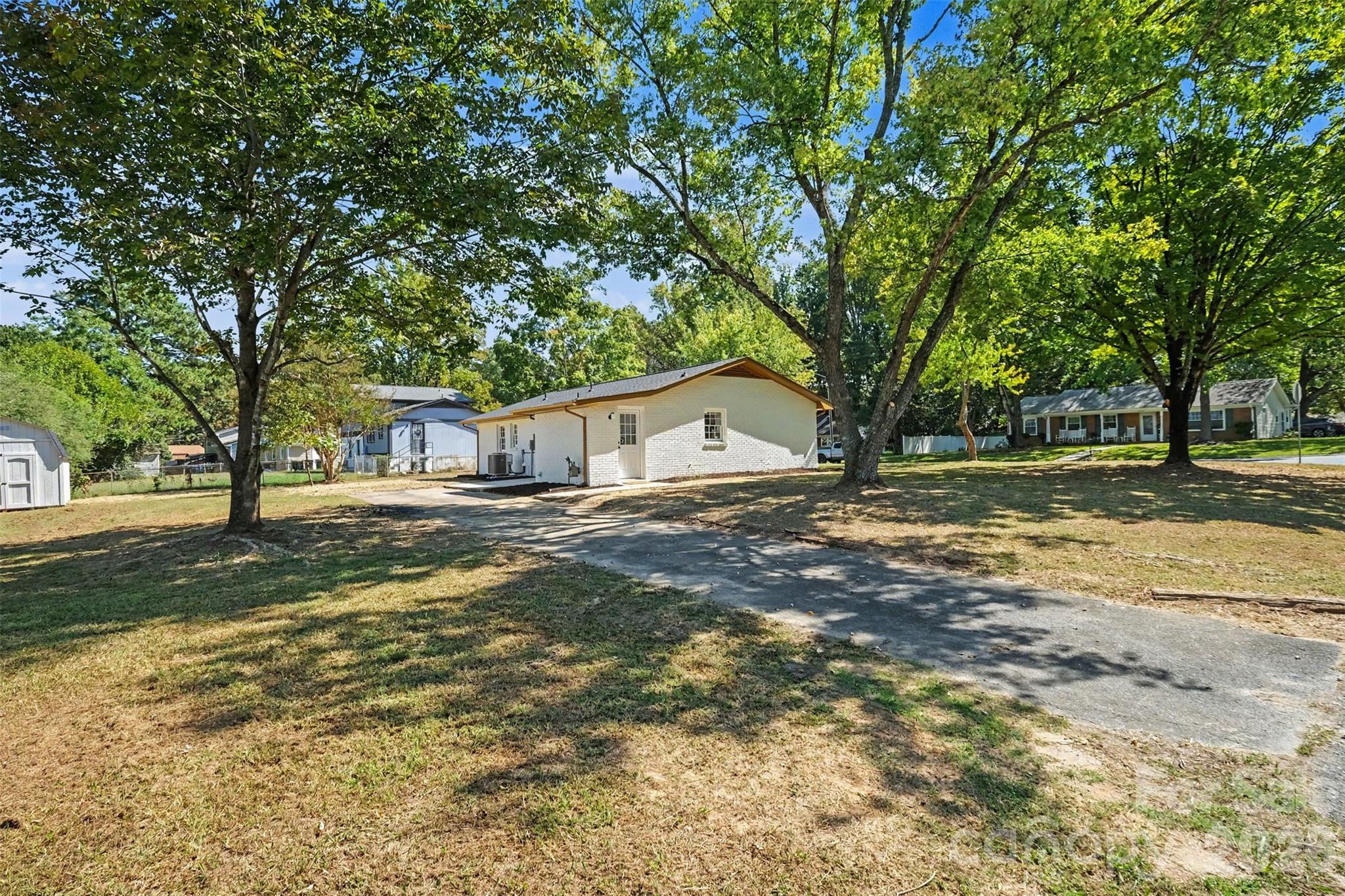 Long private driveway providing plenty of parking space for multiple vehicles, surrounding green space, and mature trees. - 3801 Hillock Court, Charlotte