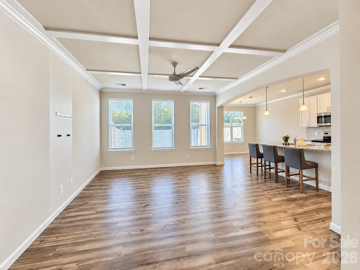 Bright and inviting living room with a beautiful coffered ceiling. - 8149 Merryvale Lane, Charlotte