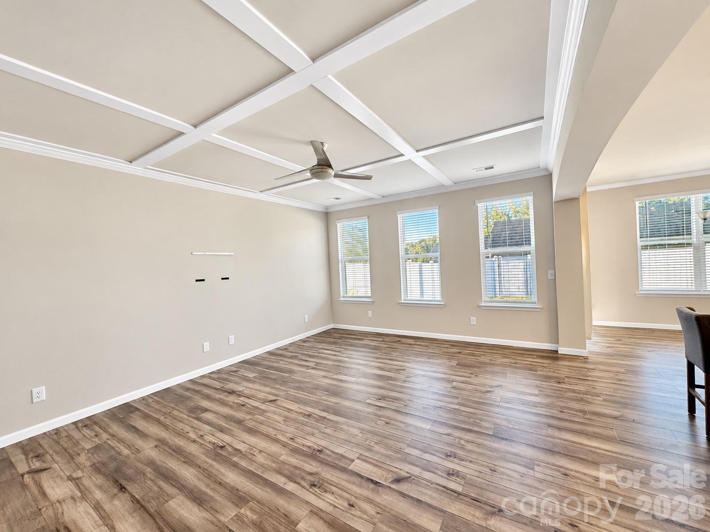 Bright and inviting living room with a beautiful coffered ceiling. - 8149 Merryvale Lane, Charlotte