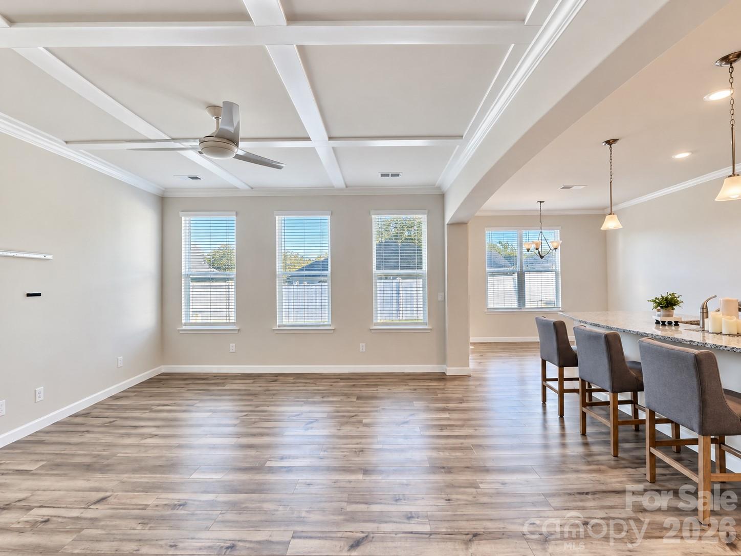 Bright and inviting living room with a beautiful coffered ceiling. - 8149 Merryvale Lane, Charlotte