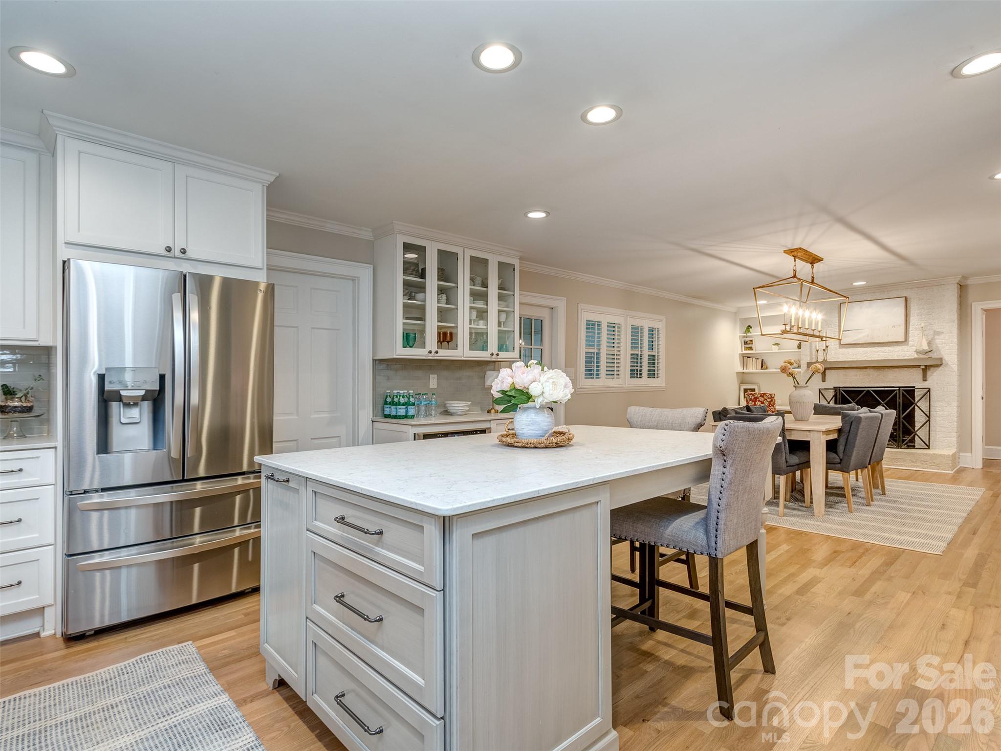 The gourmet kitchen is spectacular with updated stainless appliances, oversized island with seating area, custom cabinets & drawers, gas range, built-in shelving, pantry cabinet & more! - 6129 Page Court, Charlotte