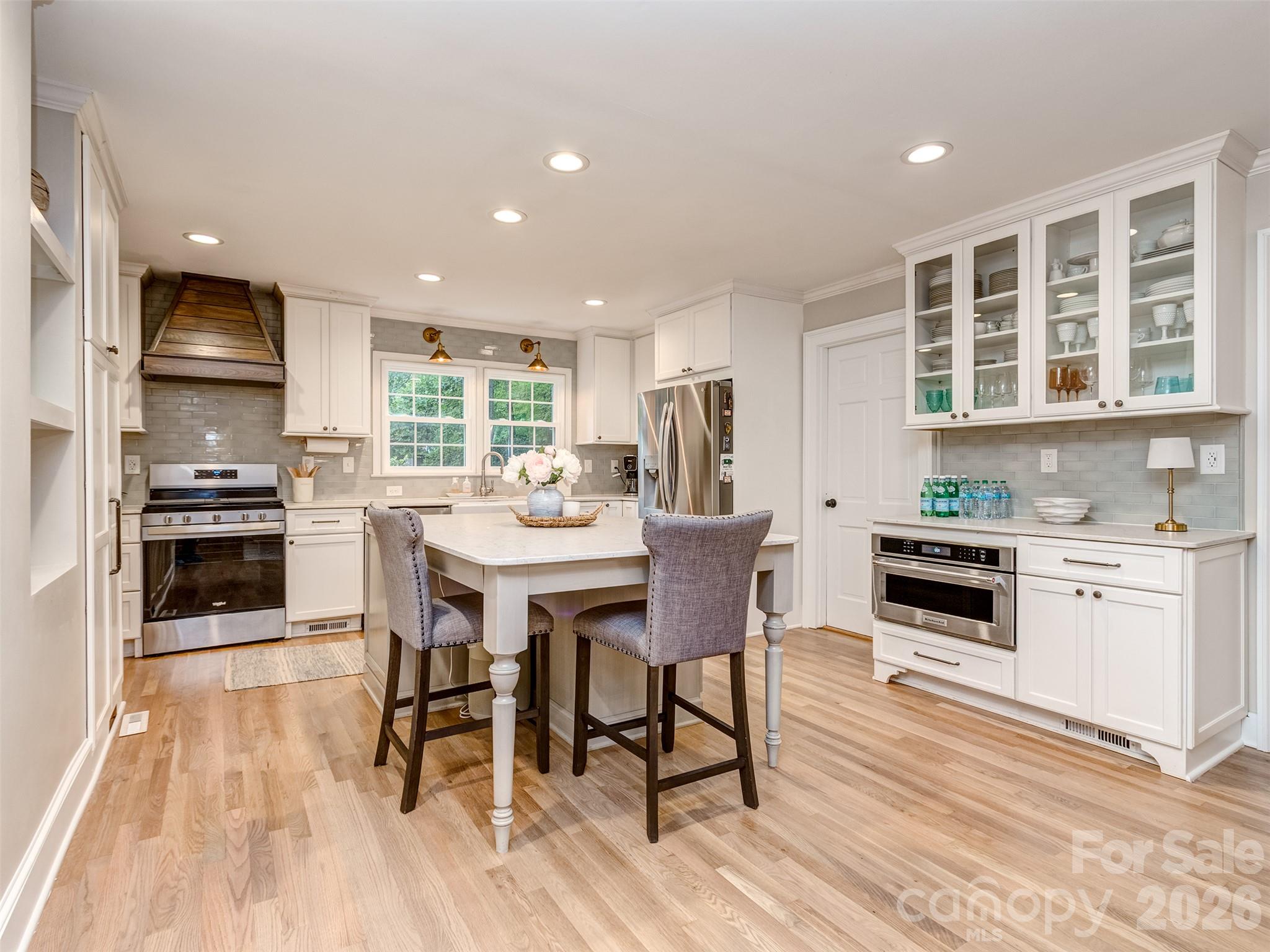 The gourmet kitchen is spectacular with updated stainless appliances, oversized island with seating area, custom cabinets & drawers, gas range, built-in shelving, pantry cabinet & more! - 6129 Page Court, Charlotte