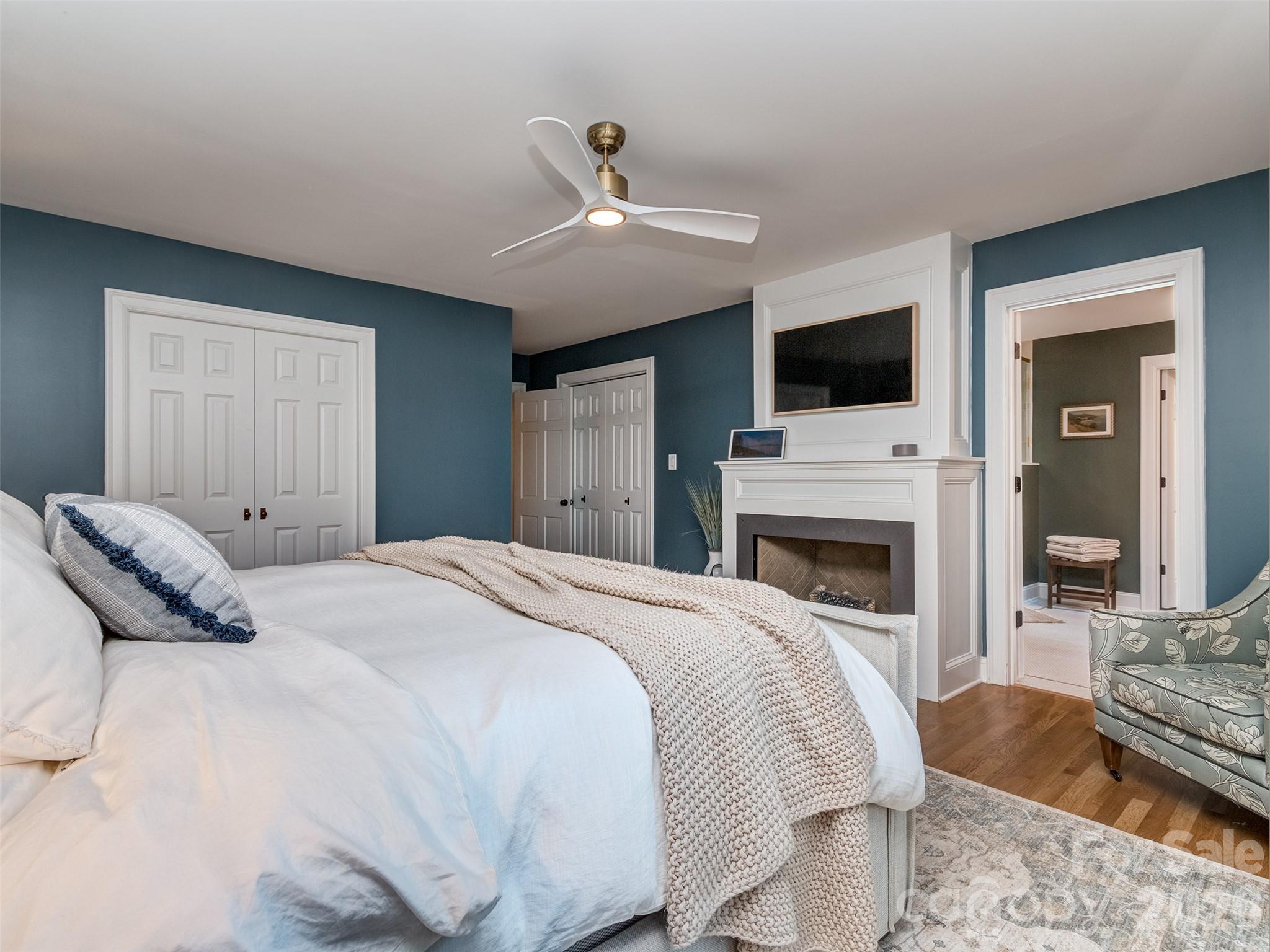 The newly reimagined Primary Suite is much larger now at 14'11" x 21'3". The site finished hardwoods, custom fireplace & newly constructed primary patio that leads to your pool & spa! - 6129 Page Court, Charlotte