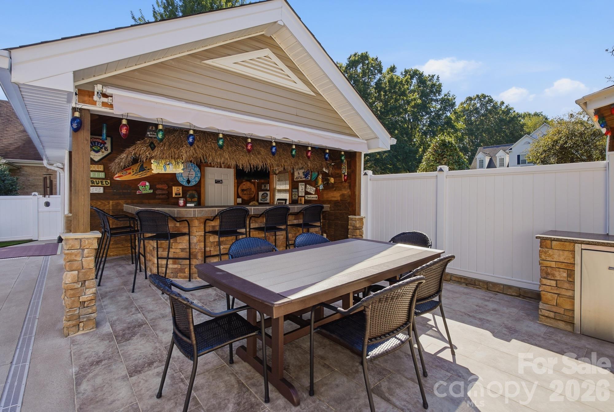 The eating area adjacent to the pool house/ bar. There is a retractable awning on the pool house that provides coverage over the eating area! - 120 Harris Farm Road, Mooresville