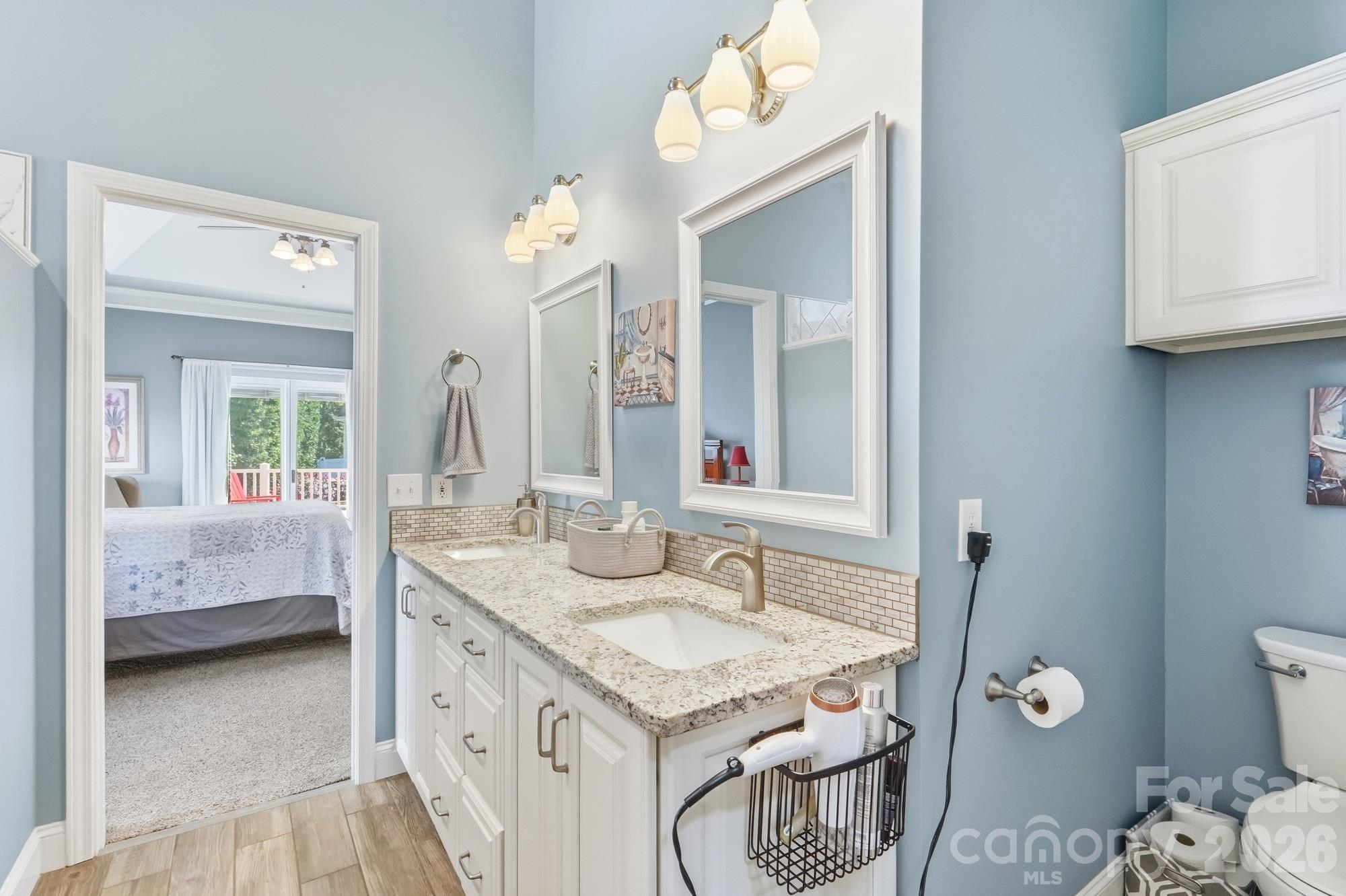 The fully updated primary bath looking into the primary bedroom and through the doors that open to the backyard oasis. - 120 Harris Farm Road, Mooresville