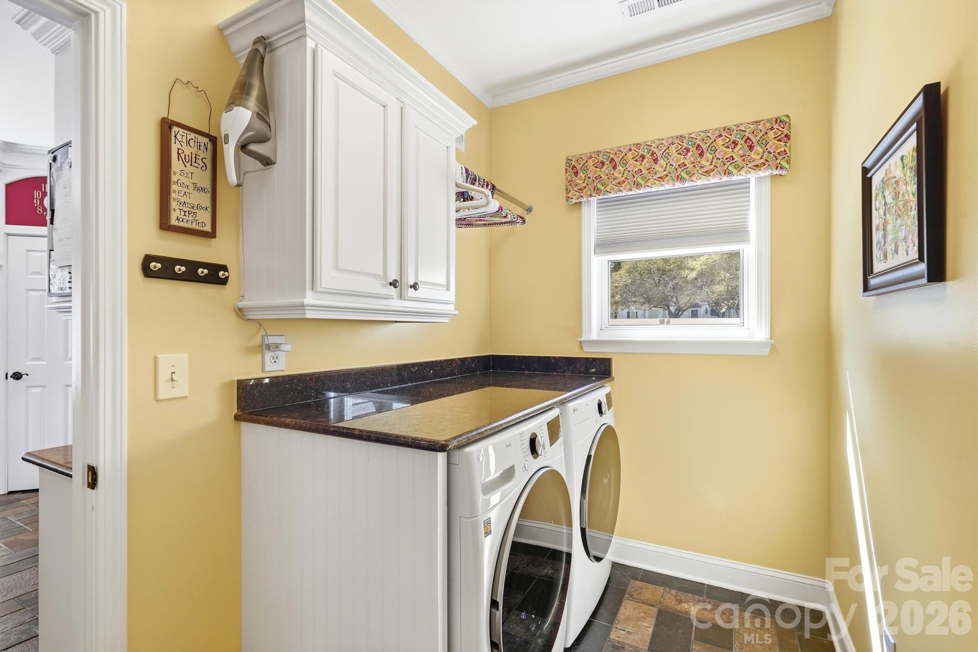 The laundry area is located off of the kitchen and has been customized to include a granite top that houses the washer & dryer and is a great area to use as a workspace. Cabinets and a drying area have also been added. - 120 Harris Farm Road, Mooresville