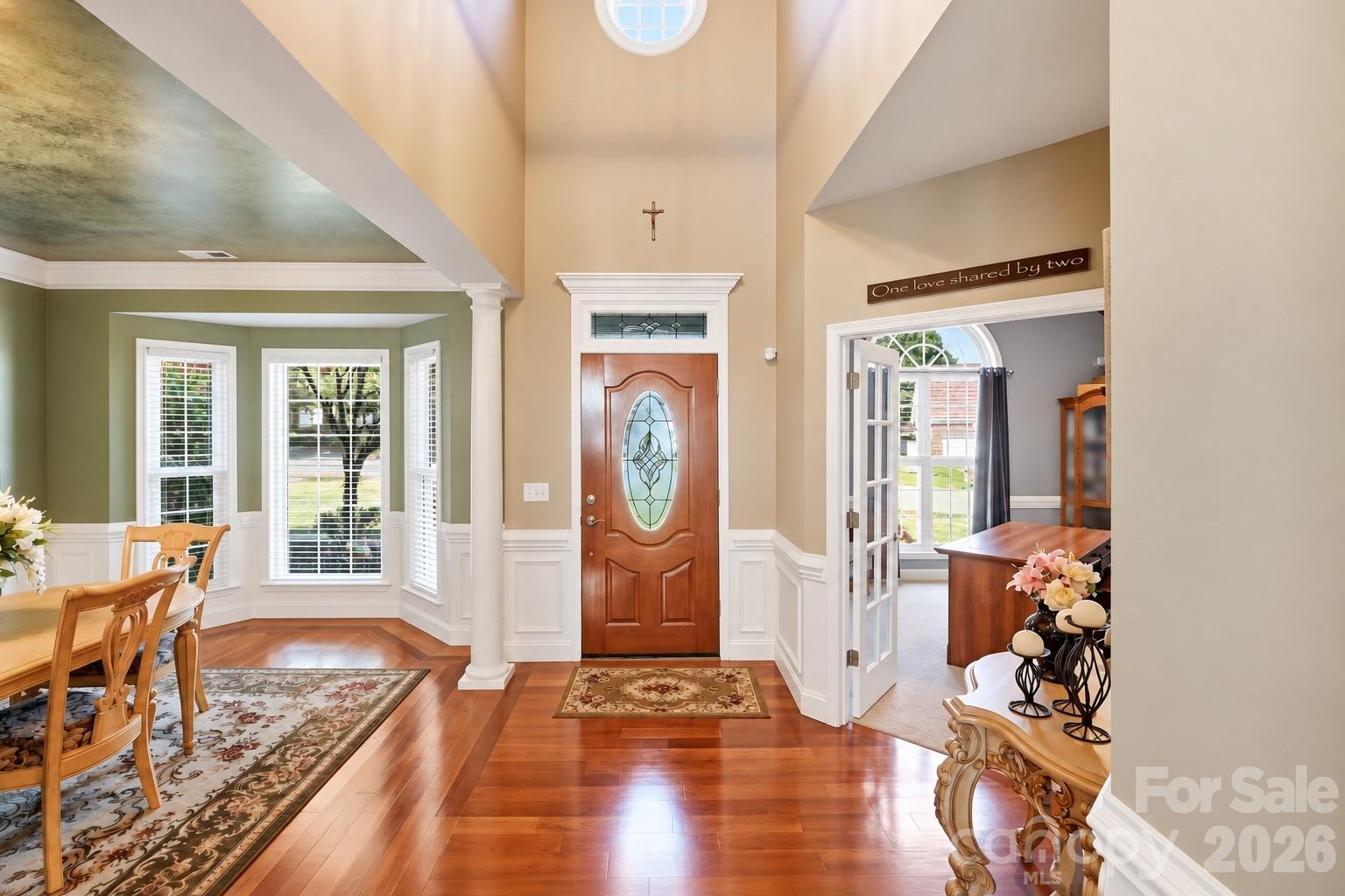 A view into the two story bright foyer that shows the dining room and office entrance with double French glass doors. - 120 Harris Farm Road, Mooresville