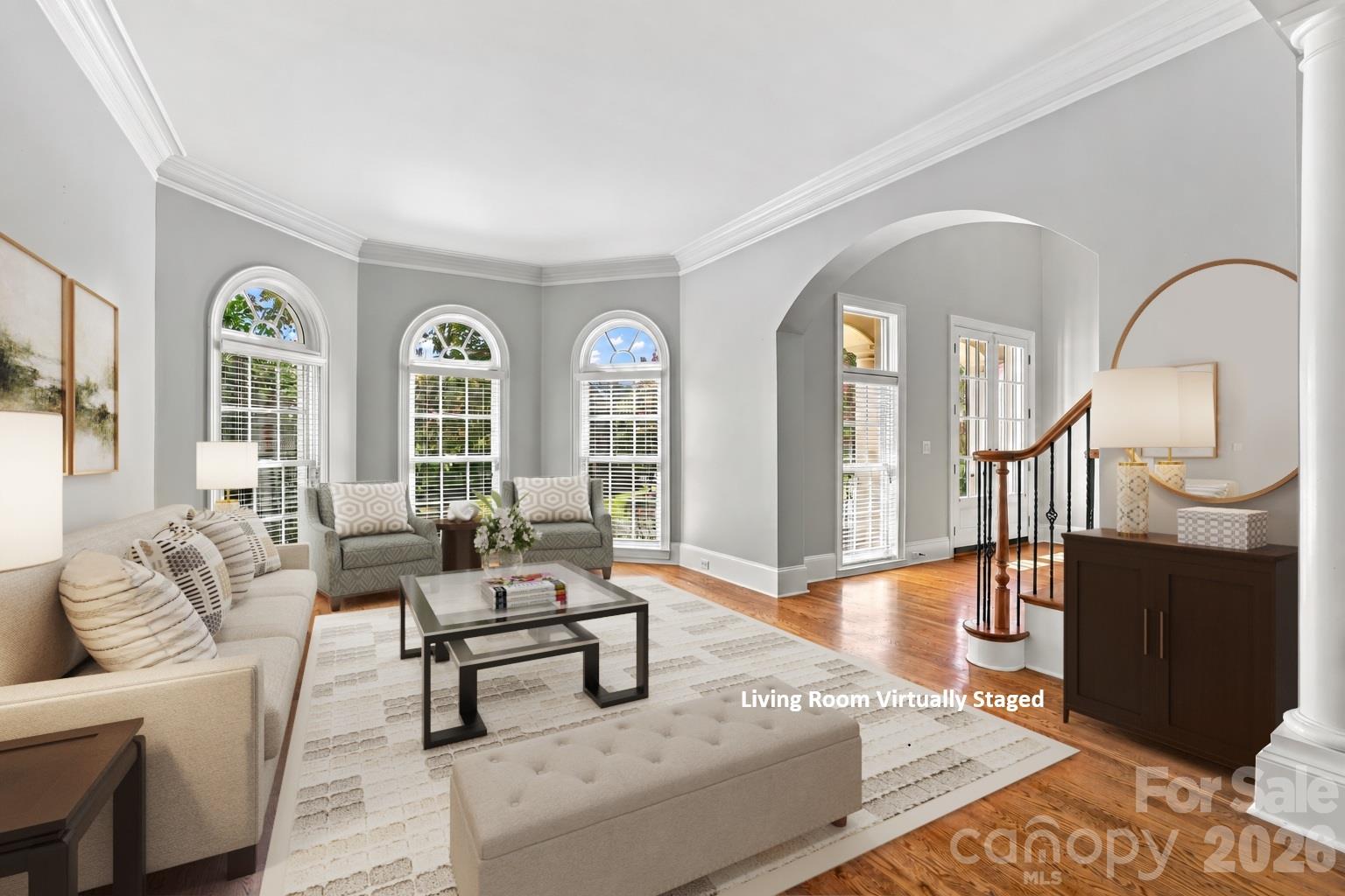 Dramatic arched windows and custom architectural details give this spacious formal living room a luxurious feel, with plenty of room for entertaining guests, visiting with friends or simply enjoying a quieter space away from the home’s more casual living areas. - 2309 Highland Forest Drive, Waxhaw