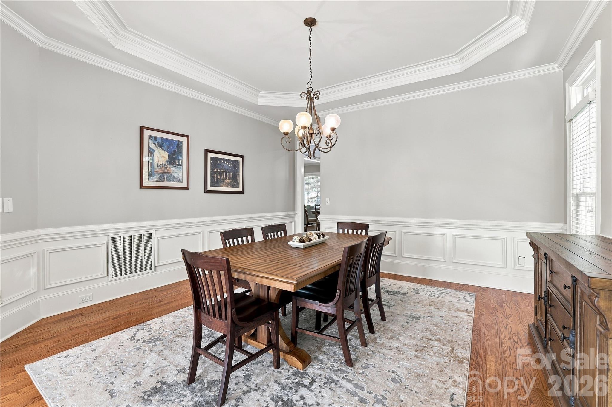 With room for a large table and plenty of guests, this formal dining room was made for everything from holiday dinners to long evenings with friends. Extensive millwork and a dramatic tray ceiling give the room a custom, upscale feel while its generous size means no one has to be squeezed around the table. - 2309 Highland Forest Drive, Waxhaw