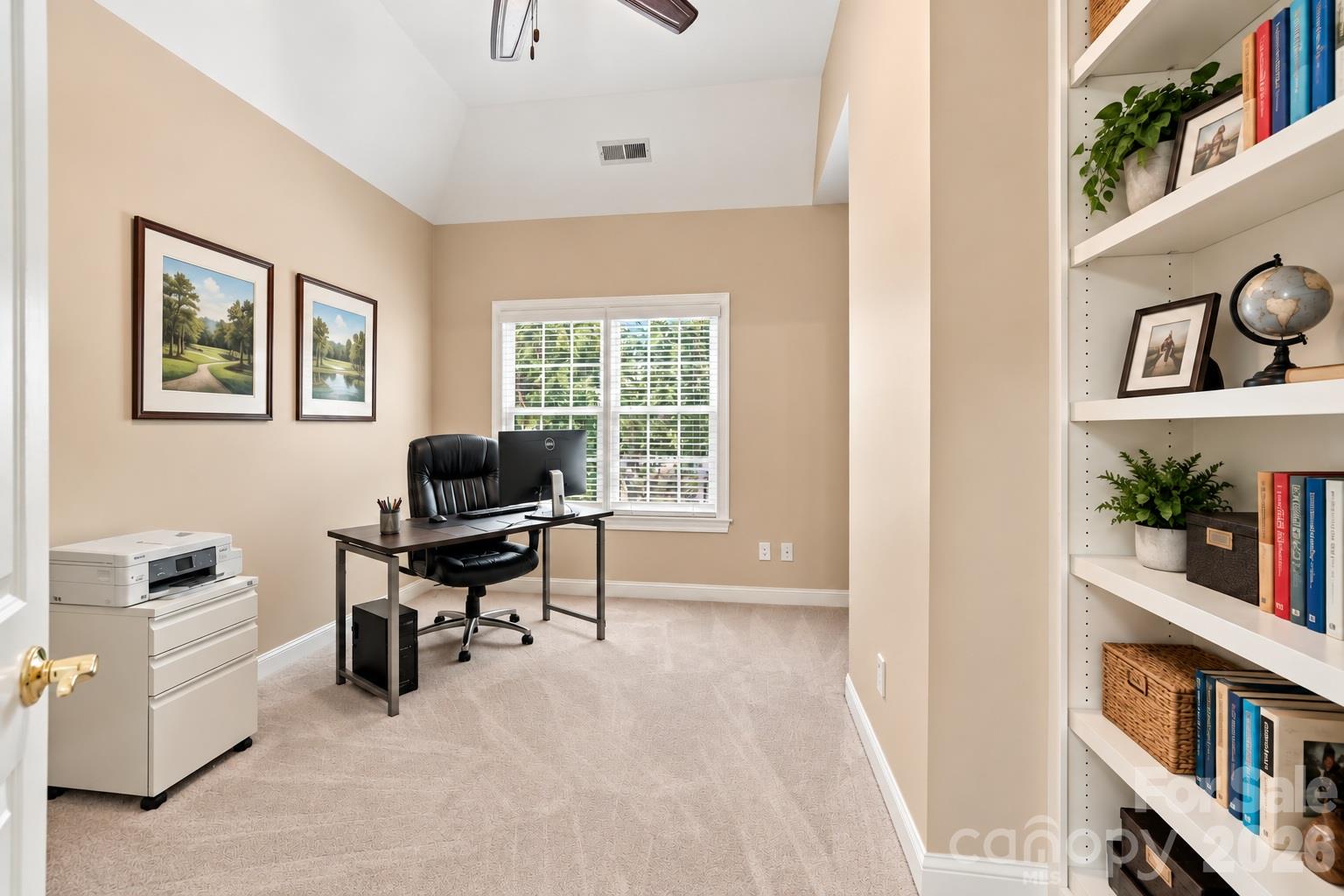Tucked behind the primary bath, this private office or library is a terrific bonus within the primary suite. Built-in bookshelves offer space for books, files and display pieces, while two windows bring in plenty of natural light. Best of all, its location creates a quiet, private place to work or read away from the activity in the rest of the home. - 2309 Highland Forest Drive, Waxhaw