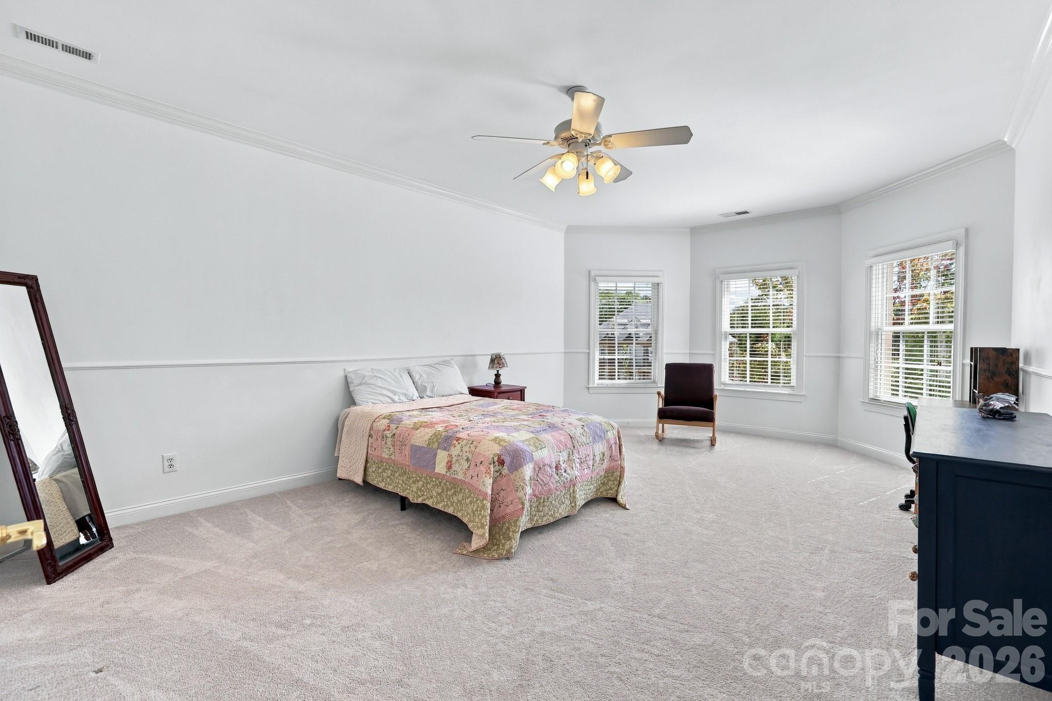 One of four additional bedrooms on the home’s second floor, this spacious room features a beautiful bay of windows that brings in abundant natural light and creates an ideal spot for a reading chair, study area or whatever else suits the person who calls this room their own. - 2309 Highland Forest Drive, Waxhaw