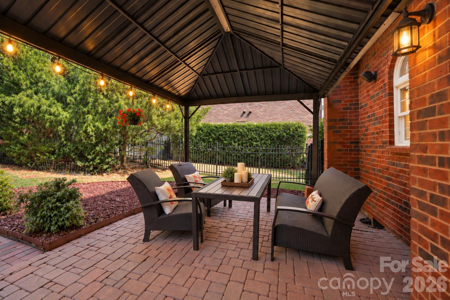 The covered brick paver patio is a natural extension of the home’s living and entertaining areas, creating a wonderful setting for al fresco dining, weekend brunches or dinner with friends. With plenty of room for a full dining table and chairs, it’s a space that makes outdoor dining and entertaining an easy part of everyday life. - 2309 Highland Forest Drive, Waxhaw