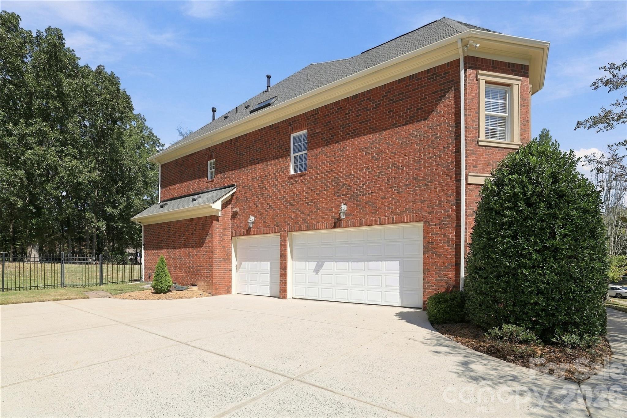 A three-car side-load garage is a major plus, providing room for multiple vehicles along with additional space for bikes, lawn equipment or other storage. The wide driveway offers plenty of room for additional parking and easy maneuvering. The side-load design allows the home’s architecture and landscaping to take center stage from the street. - 2309 Highland Forest Drive, Waxhaw